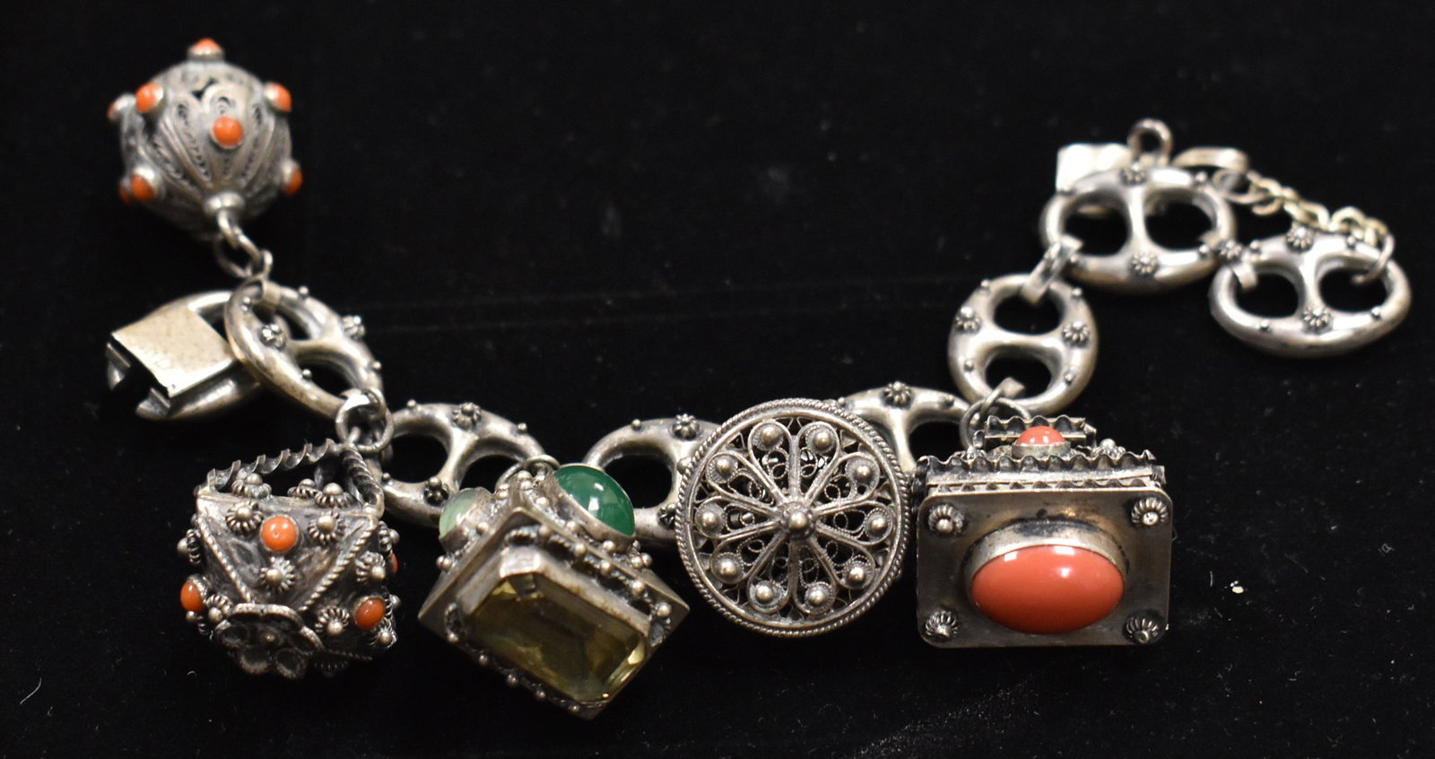 Antique .800 Silver Etruscan Five Charm Bracelet: The silver large-link bracelet has five charms with various stones including jade, coral, green stone, some are filigree and three open to reveal a box shape.