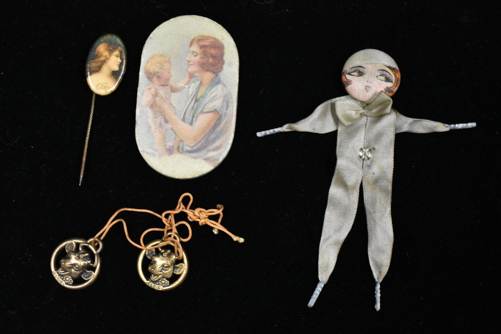 Antique 4 Piece Advertising Grouping: includes King Button Works New York silk Flapper Girl pin, Prudential flat pin cushion, Paw Paw Girl hair tonic pin, and Elsie the Cow advertising.