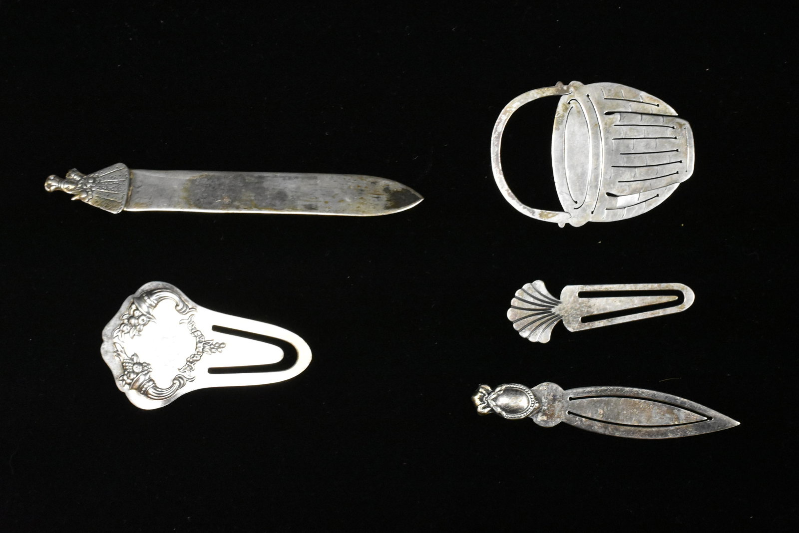 Five Antique Silver Bookmarks: Four bookmarks are sterling and one is .800 silver. One is sterling Reed and Barton, a Nantucket sterling basket, a shell and scroll in sterling. Also a .800 silver signed Nativa with a lady on top.