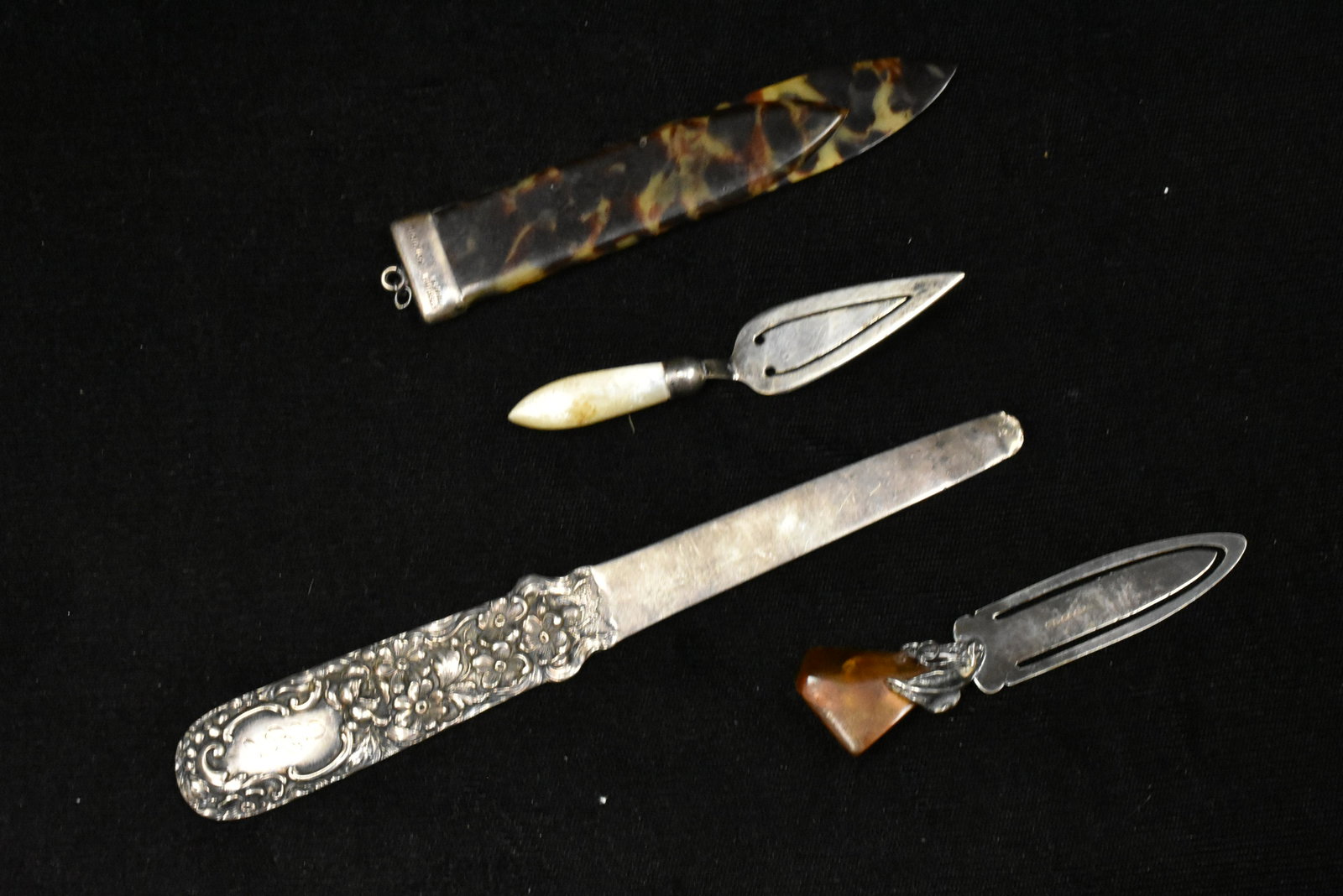 Four Antique Silver Bookmarks: includes a floral Stieff, a tortoise, a mother of pearl, and an English amber bookmark.