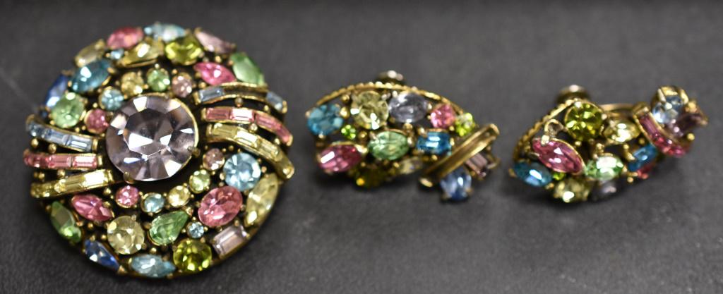 1955 Hollycraft Pastel Rhinestone Brooch Set: includes a large round brooch with colorful pastel rhinestones (around a pale purple center) and a matching pair of screwback earrings. Appears that 1 stone missing from brooch and 3 from one earring.