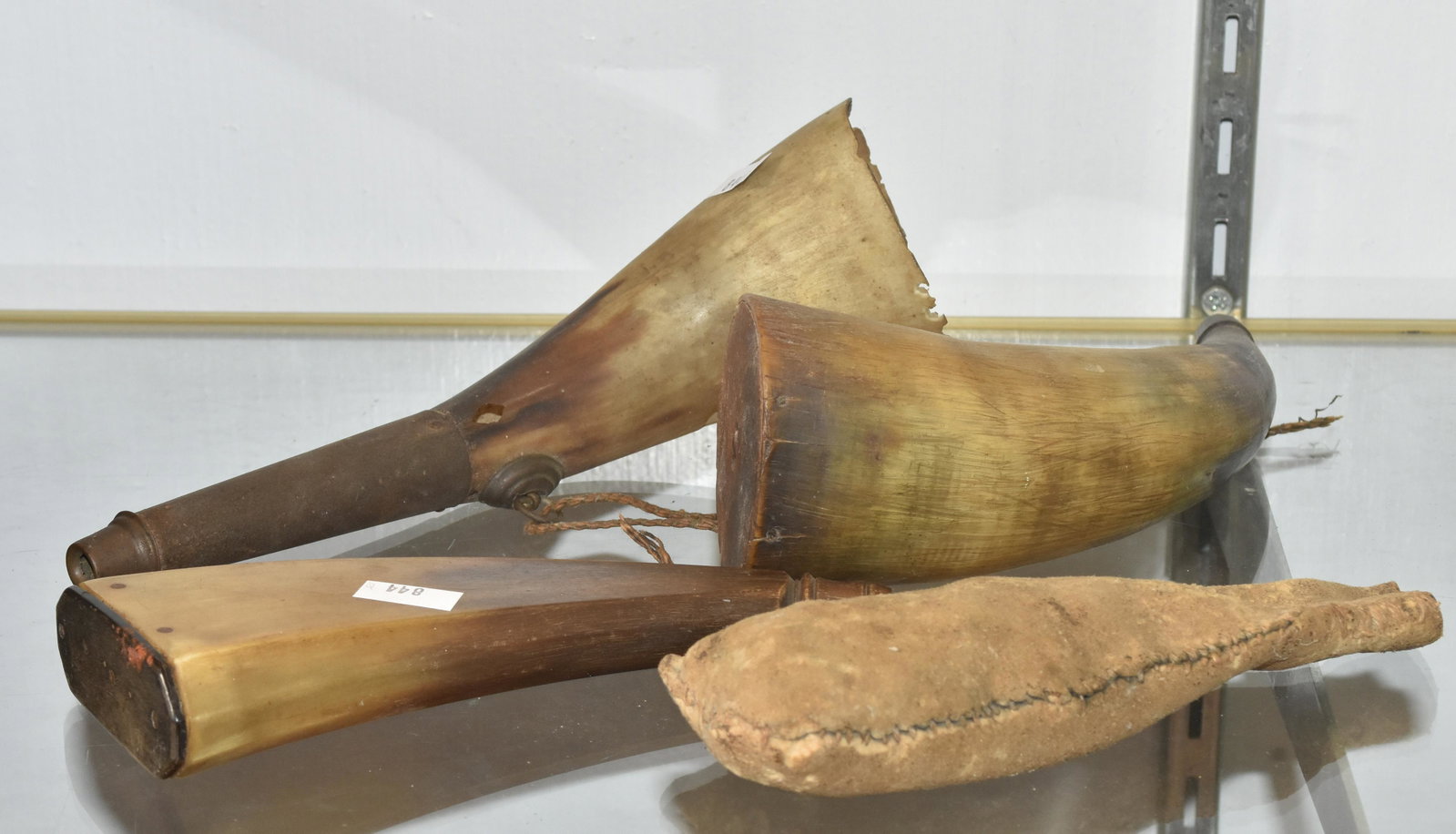 Three Early Powder Horns and Shot: Largest measures approx. 7 1/2" long and is horn and tin construction showing loss. The second is a flat horn with hand turned end and plug. It retains its end cap and shows minor loss near the cap, T