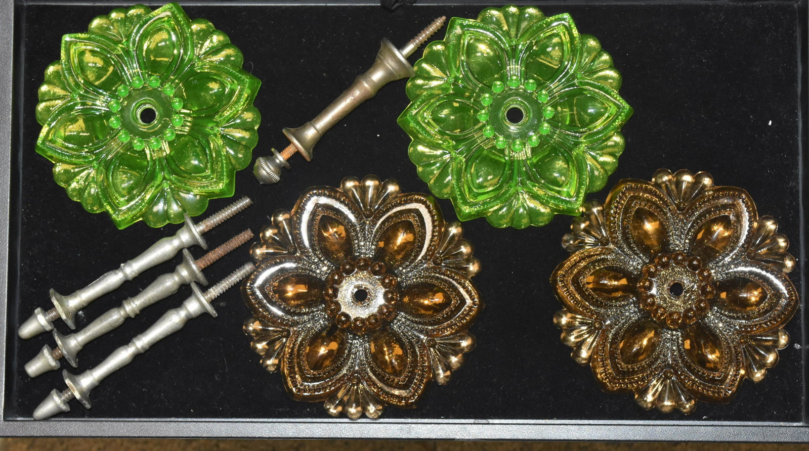 Four Victorian Glass Tie Backs: Each measures approx. 4"dia. Lot consists of a pair of Vaseline glass tie backs and a pair of amber glass tie backs. There are three matching posts and one odd post. Items were used a props on a movie