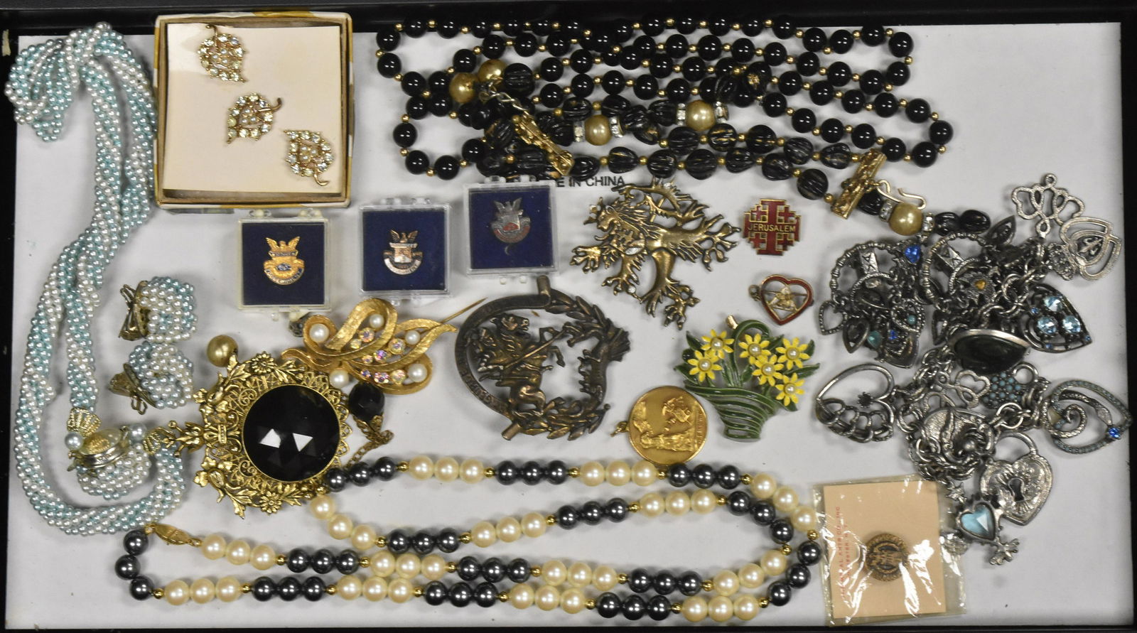 Mixed Costume Jewelry: Including a black and white faux pearl necklace marked Monet, a brass pendant brooch with large faceted stones, a St. George and the Dragon brooch, a black and gold Murano type bracelet and other item