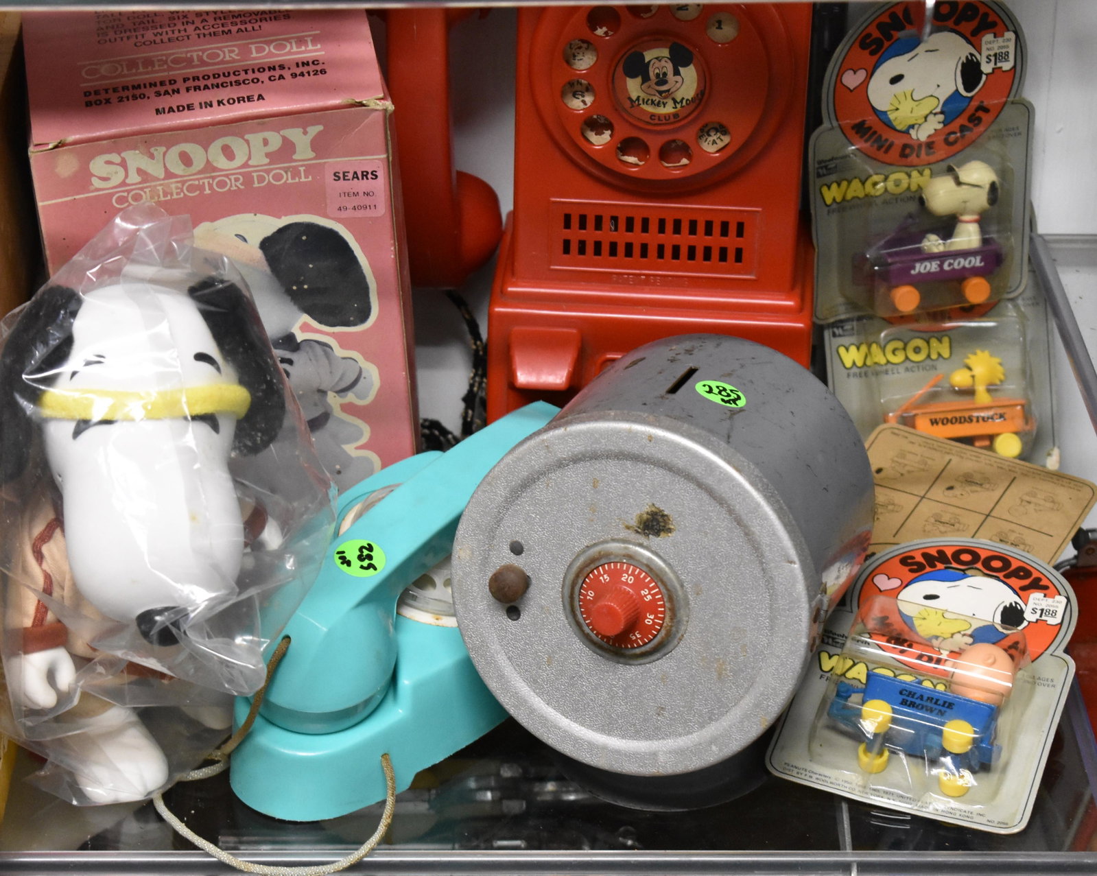 Snoopy and Mickey Mouse Toy Grouping: Lot includes a Snoopy collector's doll NIB (box dated 1958), a Mickey Mouse Club pay phone, four mini Snoopy die casts on hang card dated 1971, a plastic toy telephone and a metal bank.