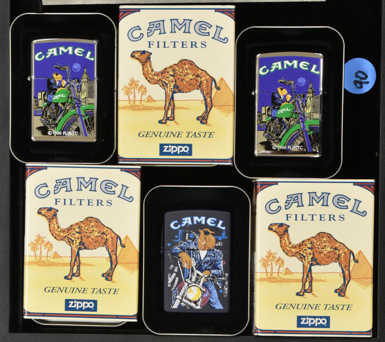 Camel Zippos (3): Three Camel cigarette Zippos with Smokin Joe, original tin and packaging, all images of Smokin Joe on a motorcycle.