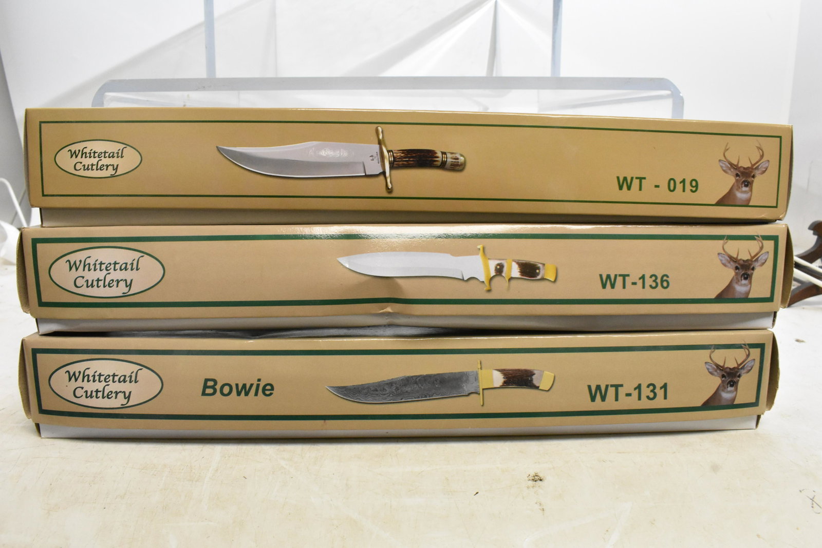 Three Frost Cutlery Knives: By Whitetail Cutlery, item #WT-019, 131, and 136, each 14" overall, Damascus-style steel blade, brass guard and leather sheath, made in Pakistan