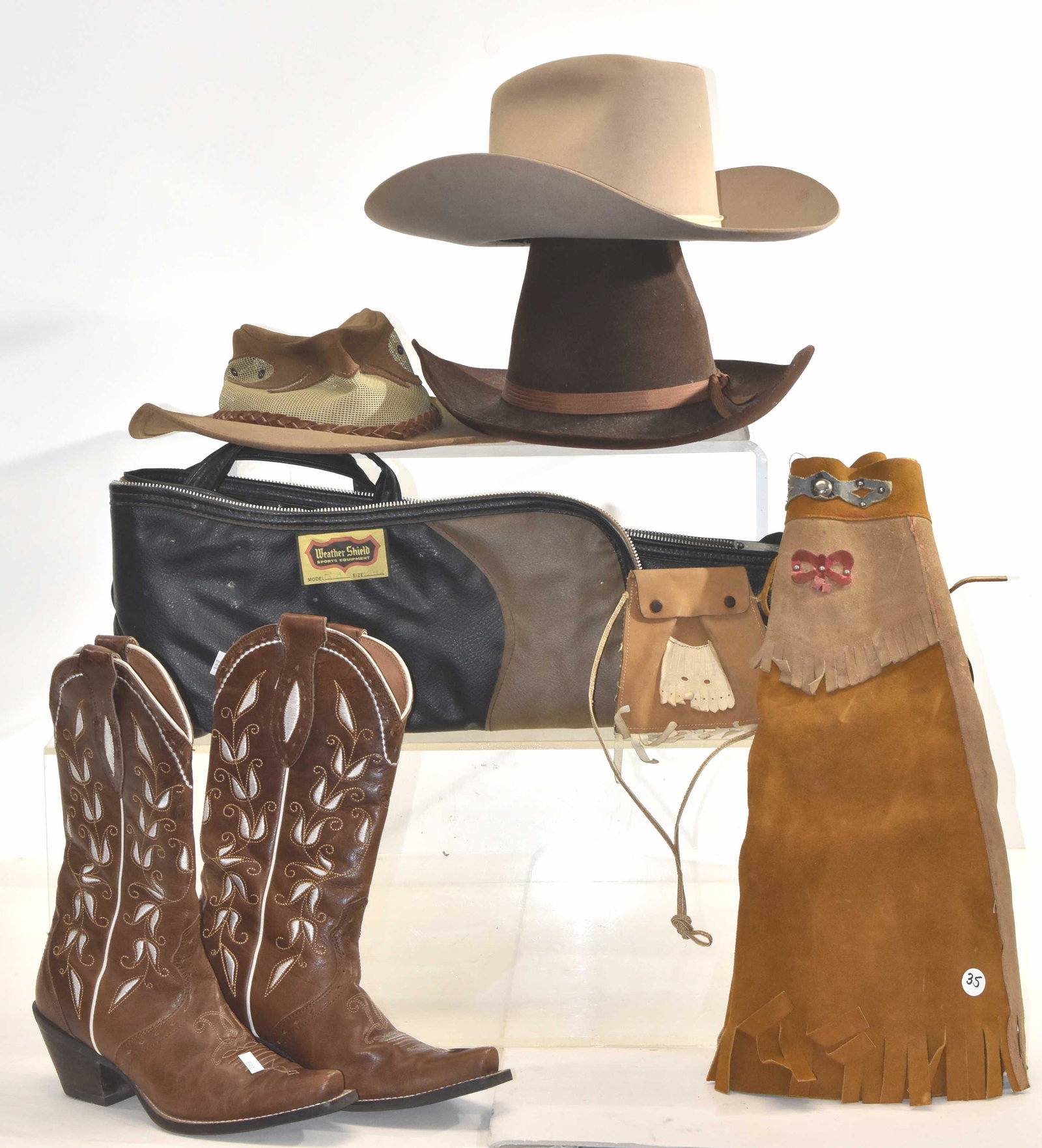 Western Clothing Grouping: A pair of Airat size 6 1/2B cowboy boots, two "Trail Ridge" felt cowboy hats, a leather child's western skirt and other items.