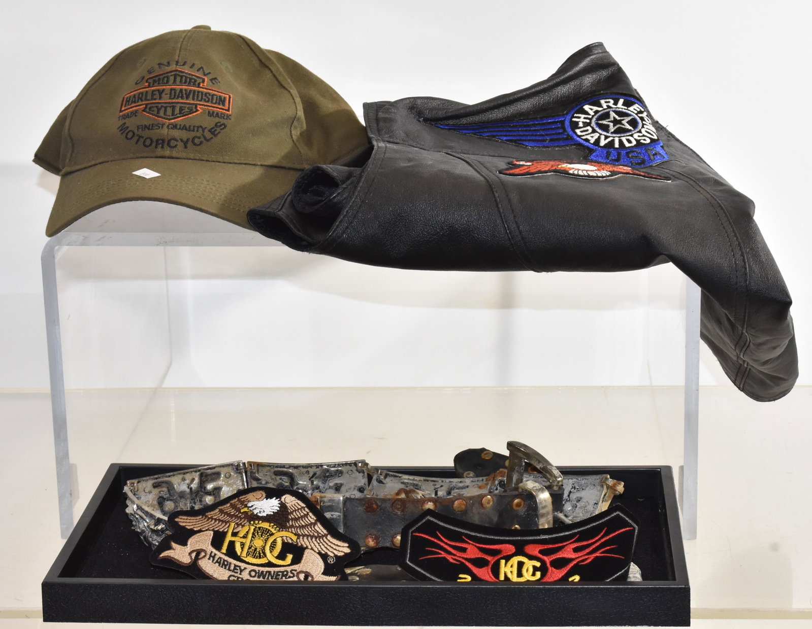Harley Davidson Motorcycle Clothing: Includes a Starling brand size 46 leather vest with Harley Davidson patches, a genuine Harley Davidson ball cap, a silver plate skull belt, a silver plate spider belt in "as found" condition and two H