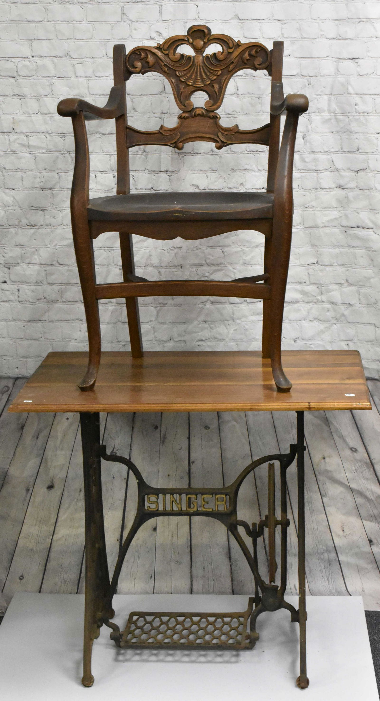 Treadle Sewing Machine Table & an Oak Chair: Measures approx. 30"h x 34"w x 23"d. Table is a Singer treadle sewing machine base with a wooden top. Lot also includes a Victorian oak chair.
