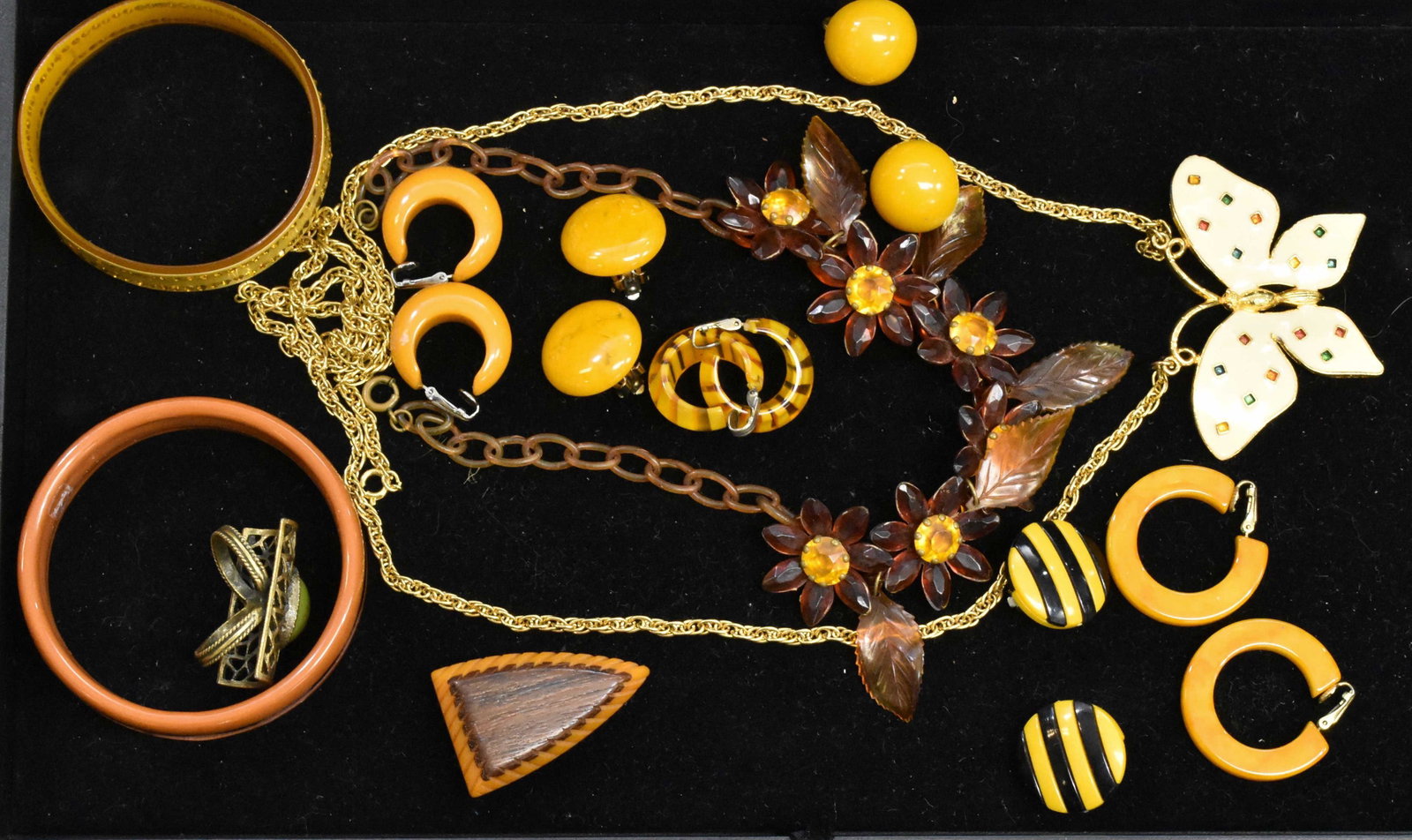 Vintage Celluloid and Bakelite Jewelry: Six pair of Bakelite earrings, a Bakelite bangle with inlay, a Bakelite fur clip with a wood inlay and other quality items.