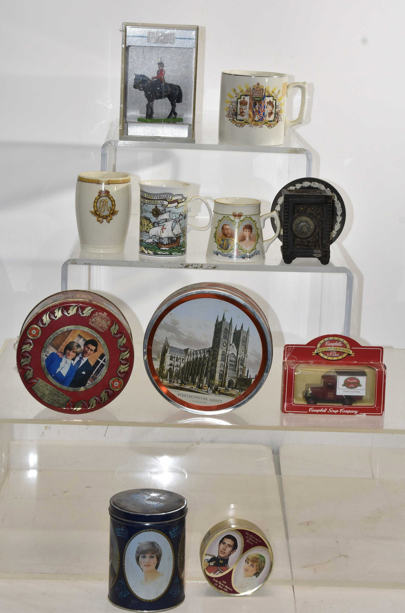 King George, Queen Mary Items and more: Including a 1911 coronation mug, a silver jubilee mug and tumbler 1935, Princess Diana candy tins, a vintage cast iron bank, a Wedgwood toddy plate and other items.