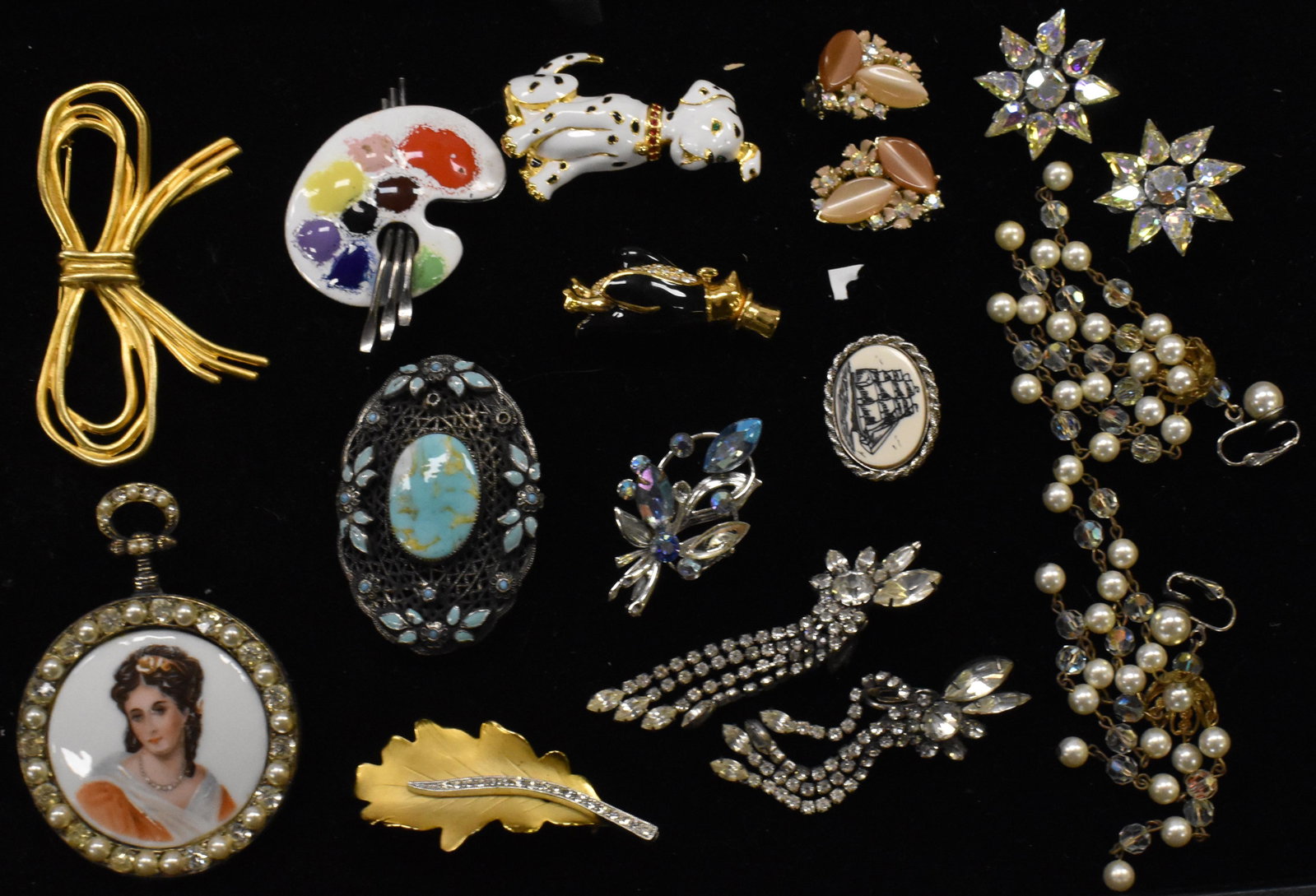 Vintage Brooches and Earrings: Including a hand painted brooch with a portrait marked "Limoges", a reticulated brooch with turquoise type stones, a Swarovski penguin pin, an enameled pallet pin, Lisner clip earrings with cream colo