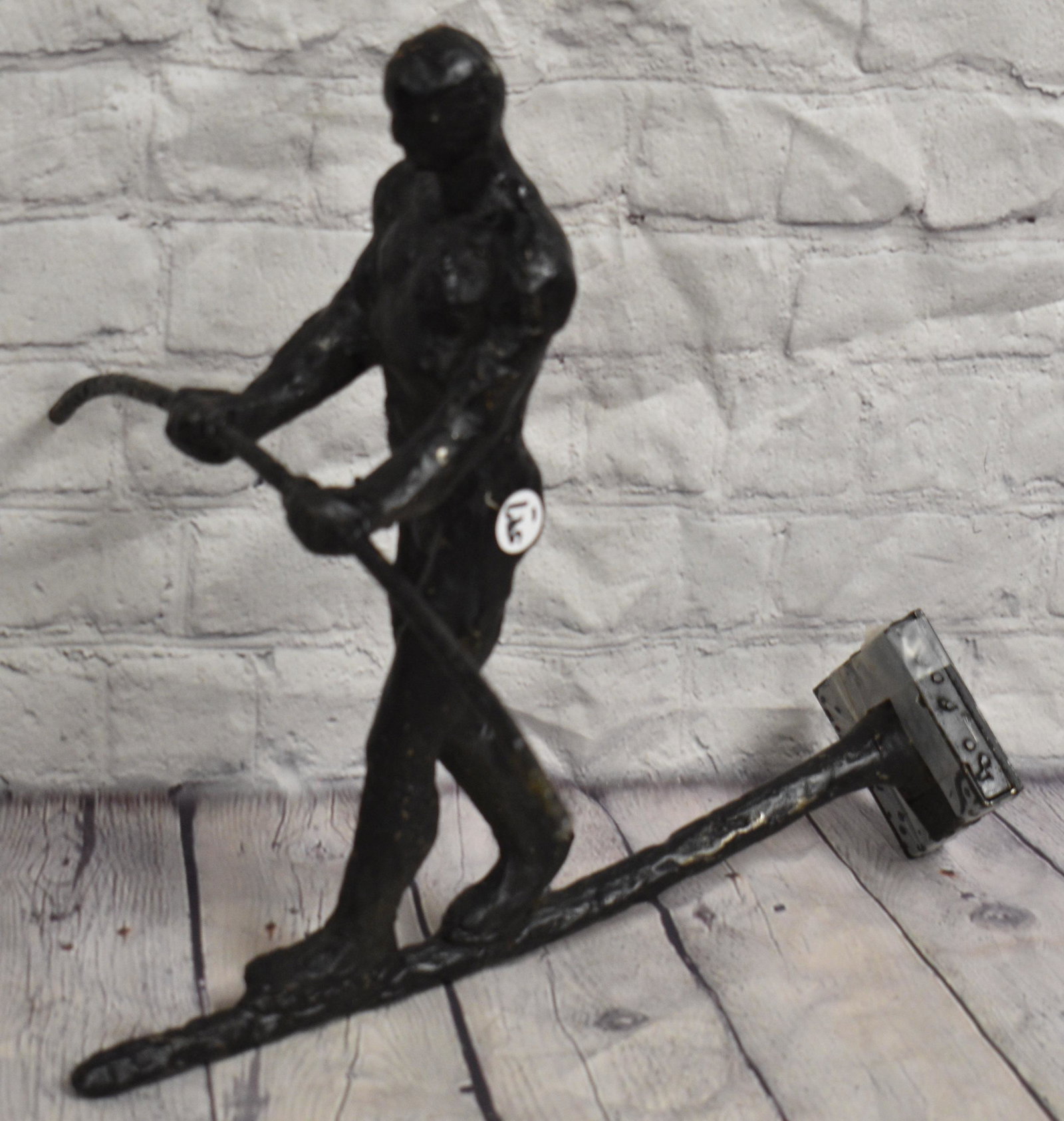 Cast Iron Figure of a Tight Rope Walker: Measures approx. 12"h x 13" in length. It is a modernist statue of a tight rope walker and is designed to mount to a wall.