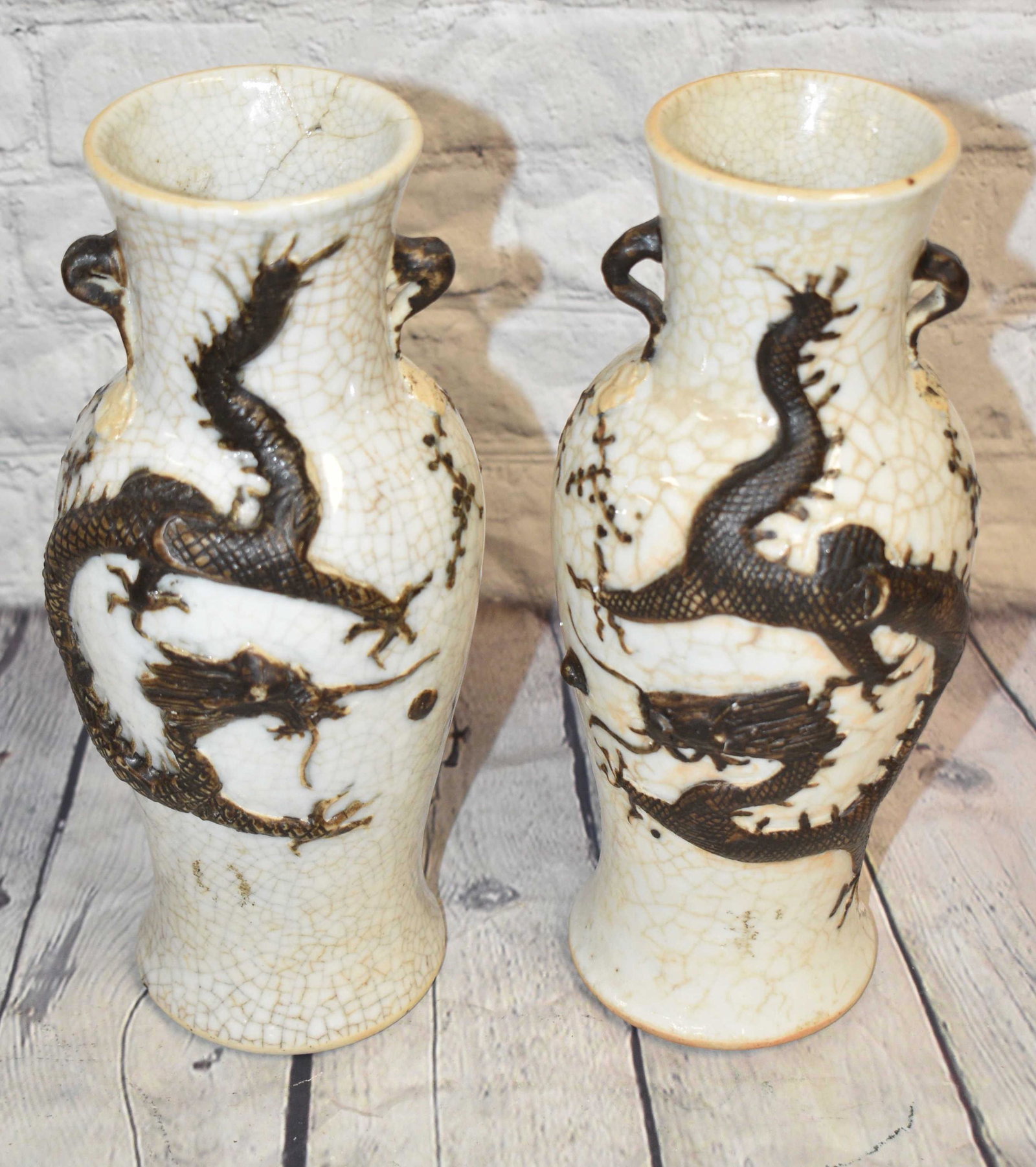 Pair of Ming Dynasty Dragon Vases: Each measures approx. 10"h. They each have a raised dragon motif, a crackled glaze, an impressed chop mark on bottom and one vase has a repair at mouth.