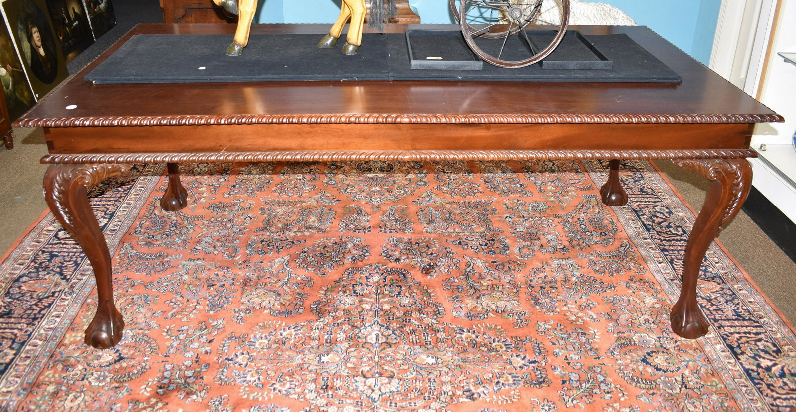 Bench Made Chippendale Style Library Table: Measures approx. 30"h x 79"w x 39"d. It has a carved edge to top, ornate dove tailed frame and stands on a claw and ball Chippendale style leg.