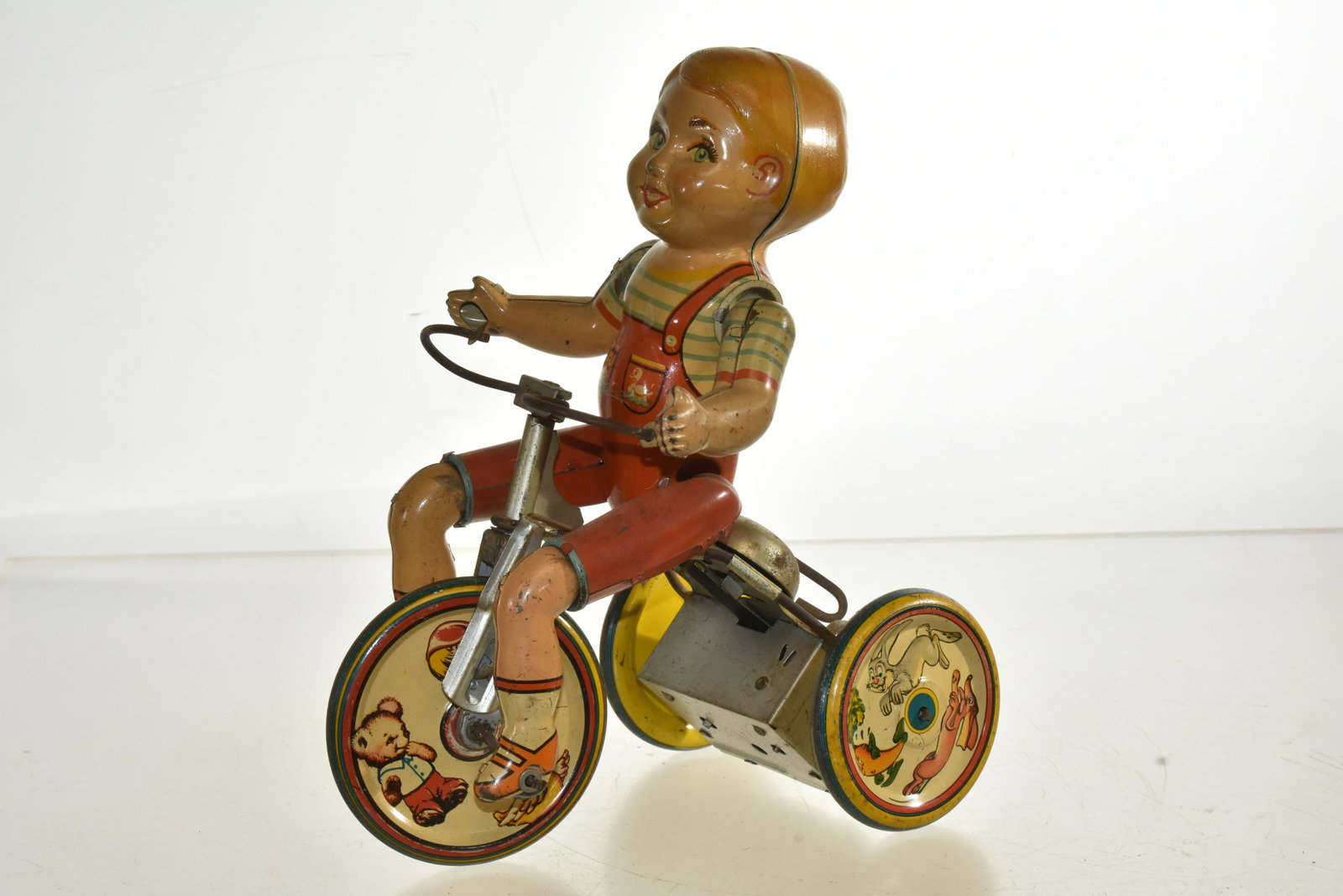 Vintage Unique Art Kiddie Cyclist Tin Litho Toy: Measures approx. 9"h. It has good lithography and is complete. Winding mechanism turns but no longer functions.