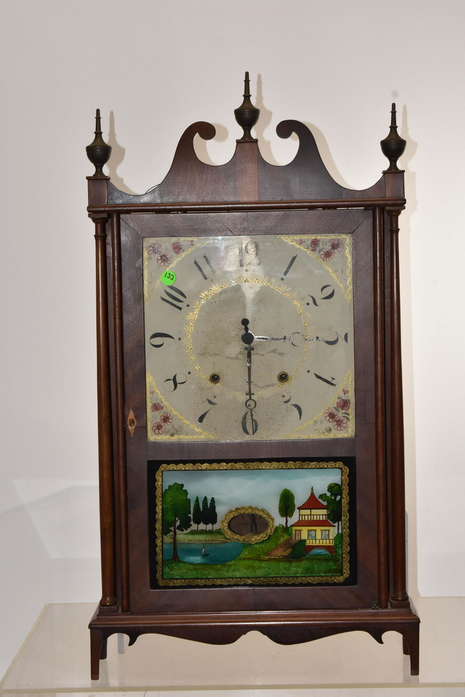 1900thC Eli Terry Pillar and Scroll Mantle Clock: Measures approx. 31 1/2"h to top of central finial. Item has the original hand painted wooden face, a repainted trumeau door, original key, pendulum & weights and original paper label Note: Clock has