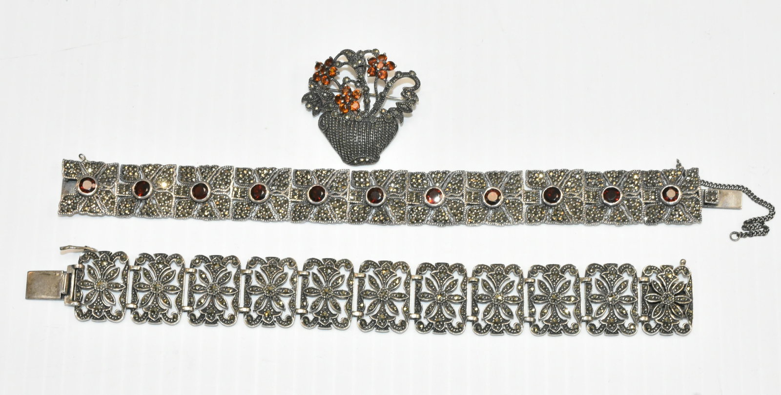Vintage Sterling and Marcasite Jewelry: Including a marcasite basket pin with amber color stones, a wide sterling marcasite daisy bracelet and a sterling bracelet with garnets.