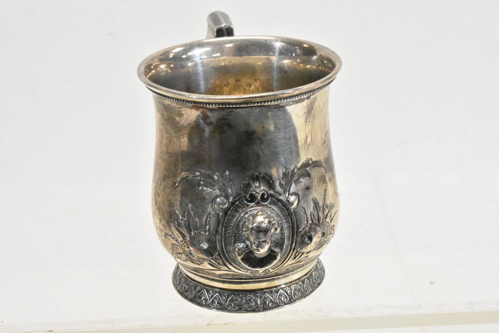19th Century "Walker & Hall" Sterling Baby Cup: Measures approx. 2 3/4"h. It has a three dimensional angel on face surrounded by flowers and a "W & H' mark on the bottom and a 900/1000 mark.