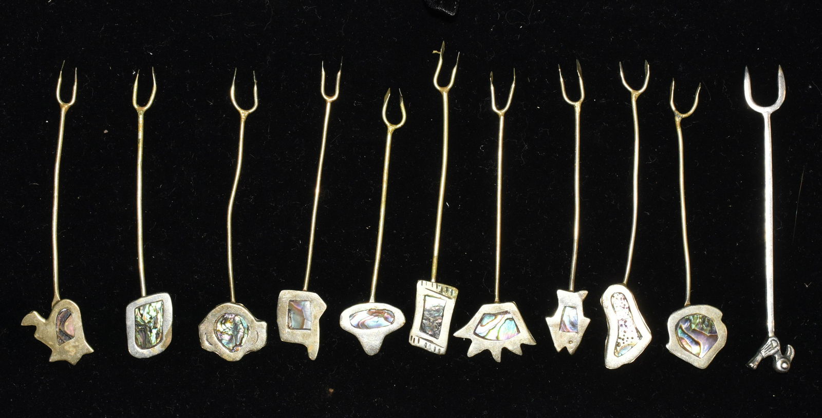 Set of Sterling Abalone Hors D'ouvres Forks: Set of ten cocktail forks measuring approx. 3 1/2" each. All have abstract finials with abalone inlay. Lot also includes a silver cocktail fork with a bird finial. 1.06 ozt