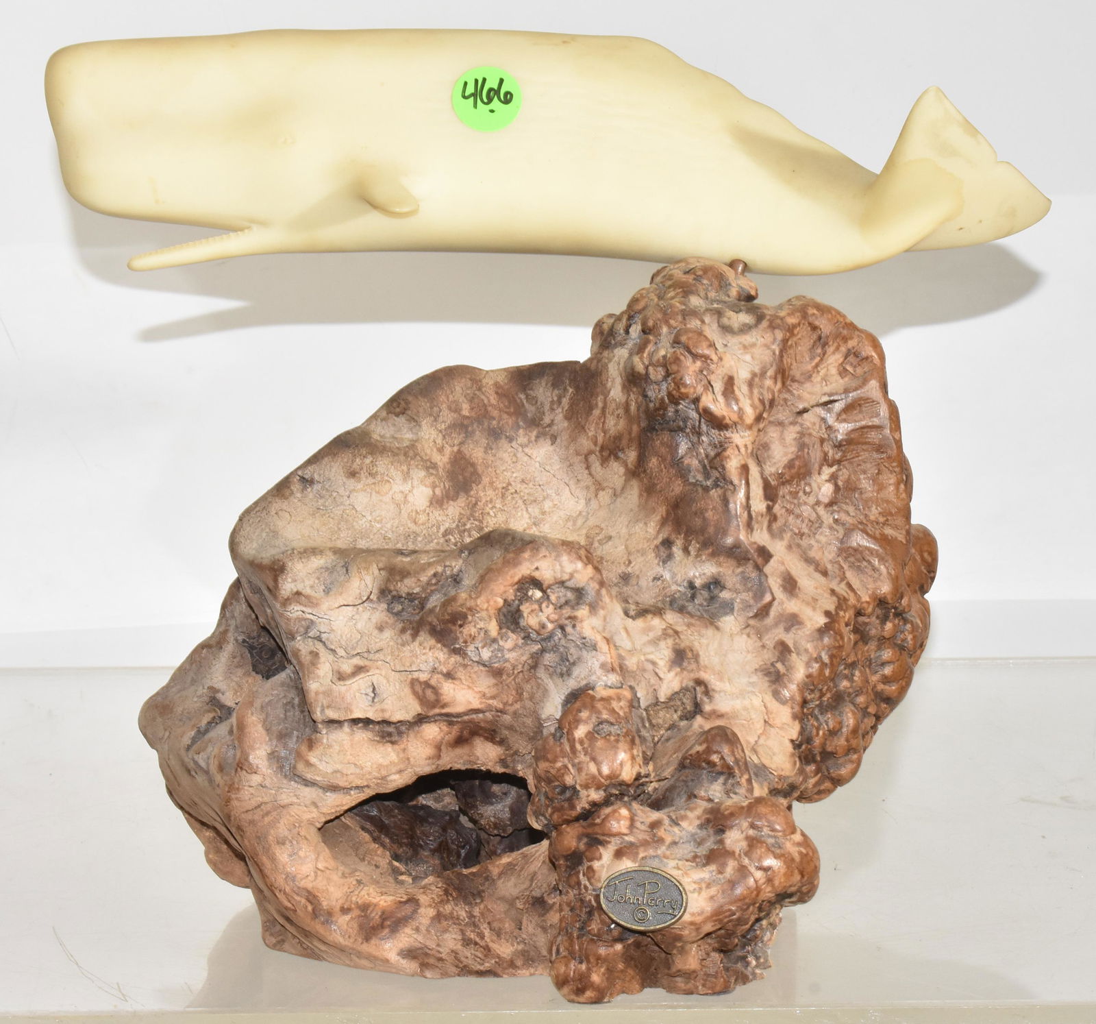 Figure of Moby Dick on Driftwood: Measures approx. 9"h x 11"w. It is a resin figure of Moby Dick and sits on a large piece of driftwood. Artist John Perry.