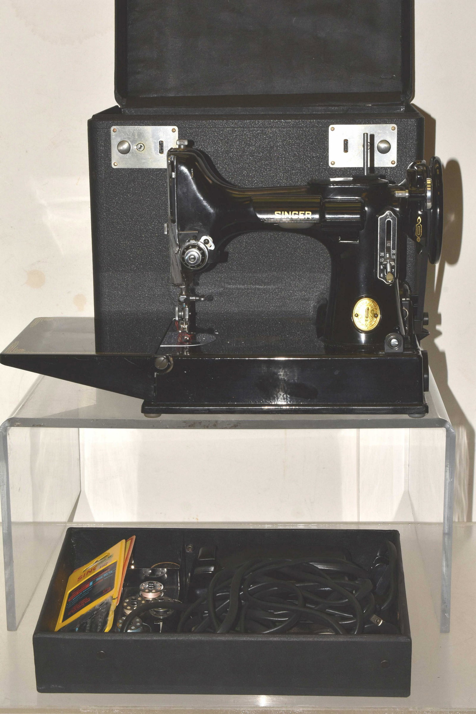 Singer Featherweight Sewing Machine: Sewing machine is catalog #3-120. It has a clean body with good gold flashing and comes with a pedal, a good cord and a selection of accessories. Comes in original case (extra fine condition). Numbers