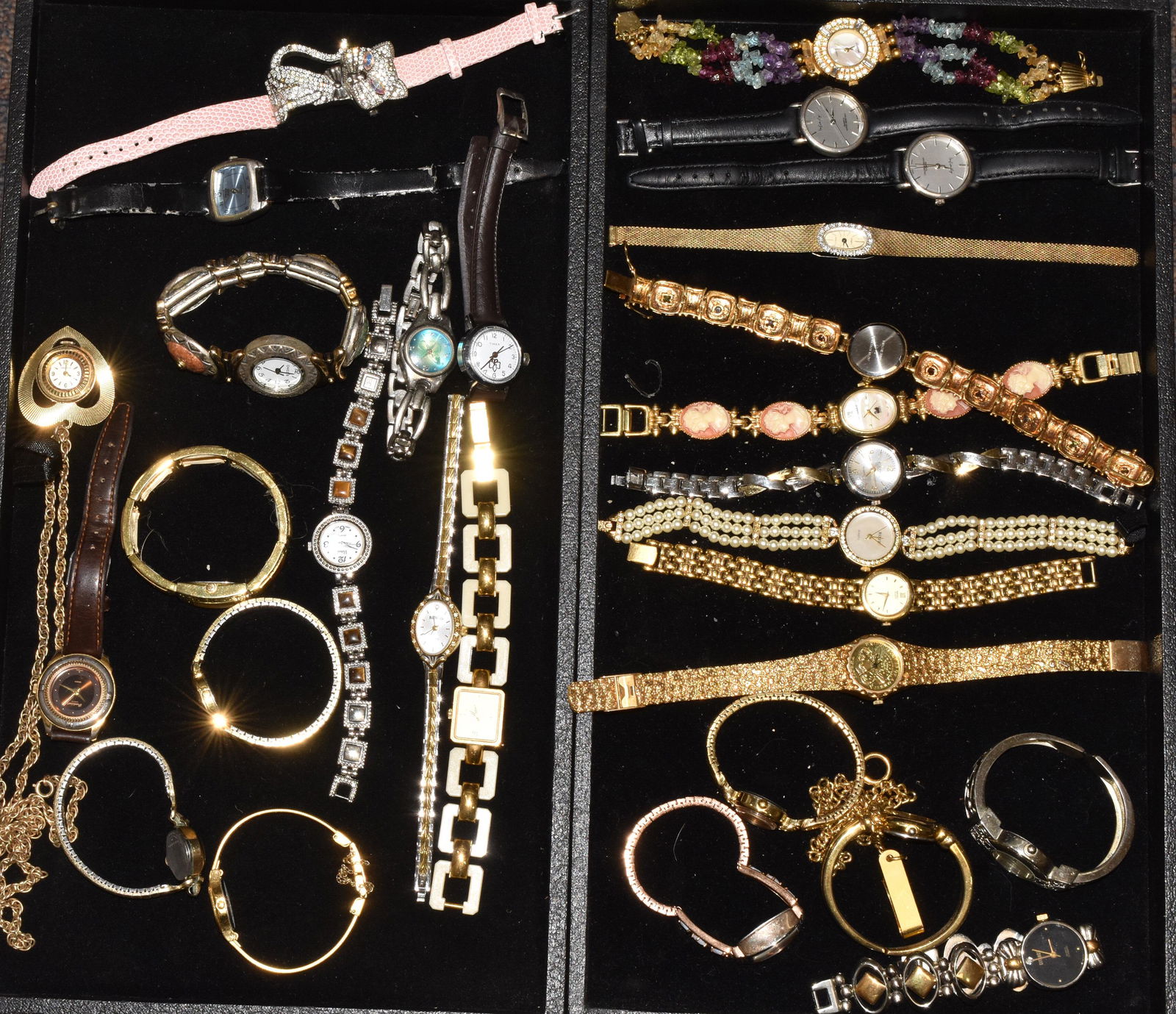 Two Trays of Lady's Watches: A gold tone watch with an American Eagle face, a Gloria Vanderbilt with a cameo band, a Gruen quartz with a mesh band, a vintage Caravelle and many others.