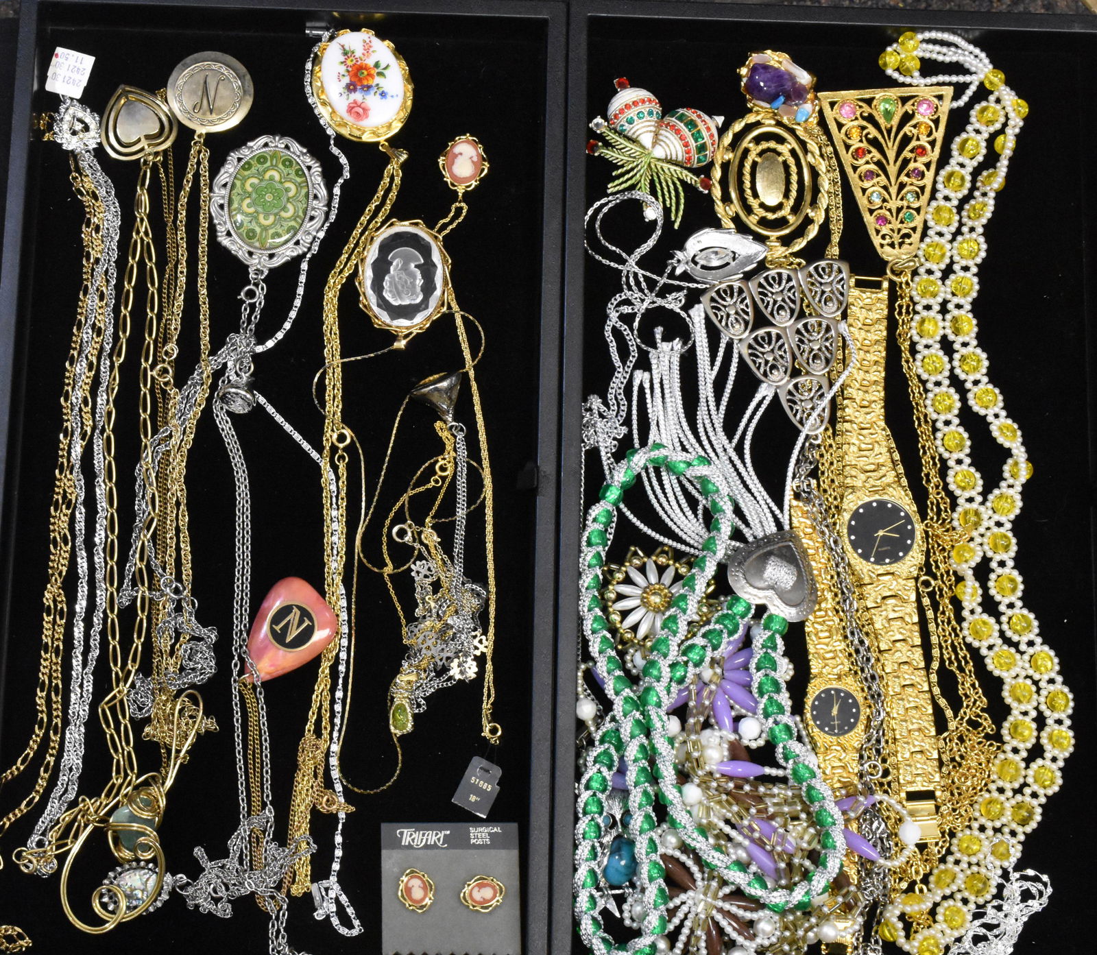 Two Trays of Costume Jewelry: Including two gold tone wrist watches with black faces, Sarah Coventry necklace with a rhinestone, two cameos - one marked Trifari, Trifari cameo earrings and various necklaces.