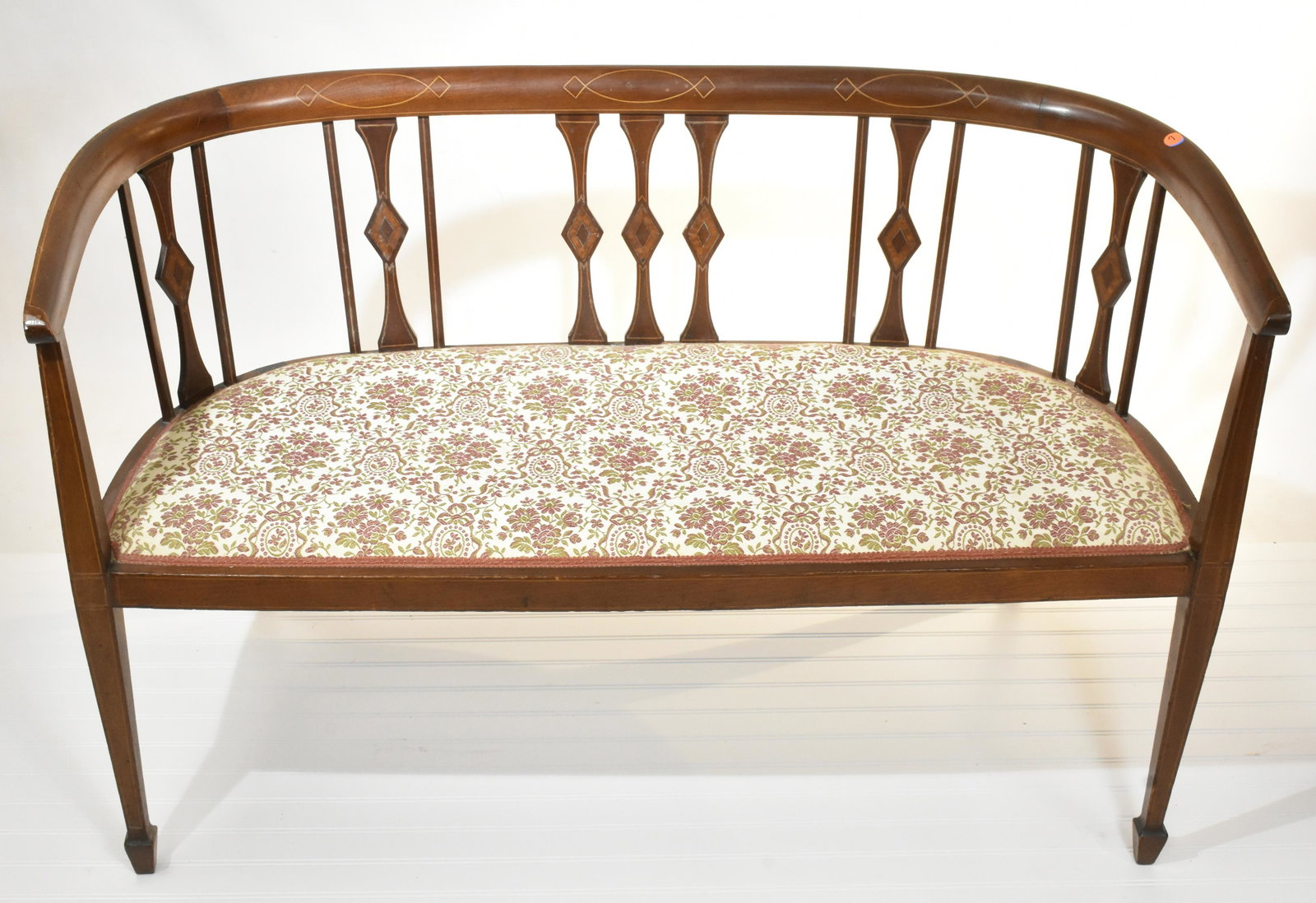 Inlaid Mahogany Settee: Measures approx. 29"h x 45"w x 20"d. It is mahogany construction with multiple wood inlay. Settee is nicely upholstered and dates to the late 19th/early 20th century.