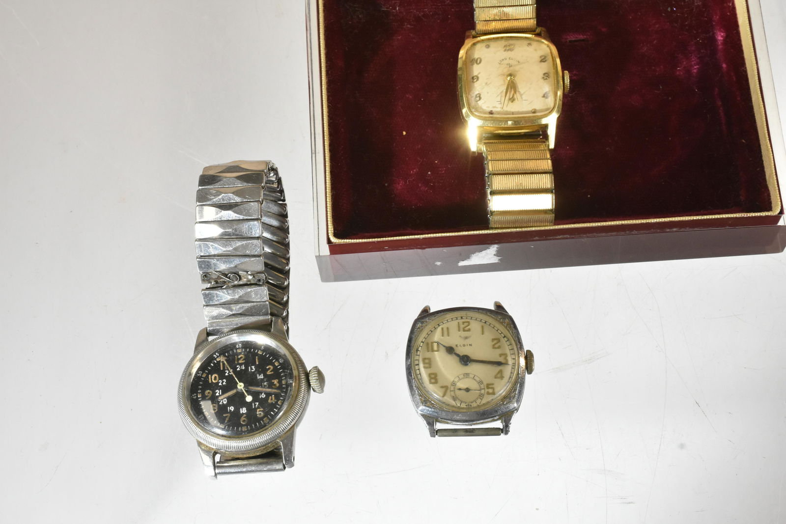 Vintage Watches: A gold fill Lord Elgin in original box, a 1930's stainless steel Elgin and a Waltham type A/17 military wrist watch circa 1950.