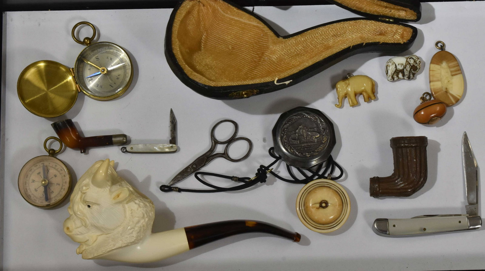 Meerschaum Figural Pipe and Eclectic Grouping: Including a Meerschaum pipe in the figure of a bull's head with original leather case, a small brass French compass, two pocket knives with mother of pearl bodies, an early glass football pendant, oth