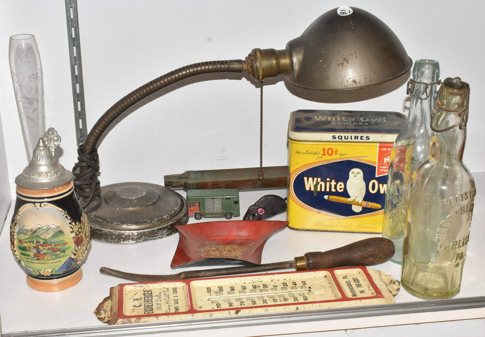 Advertising and a Desk Lamp: A C.H. Eichelberger advertising thermometer measuring approx. 13: in length, a ten cent White Owl tin, two local advertising bottles, a flexible desk lamp. a stein and other miscellaneous items.