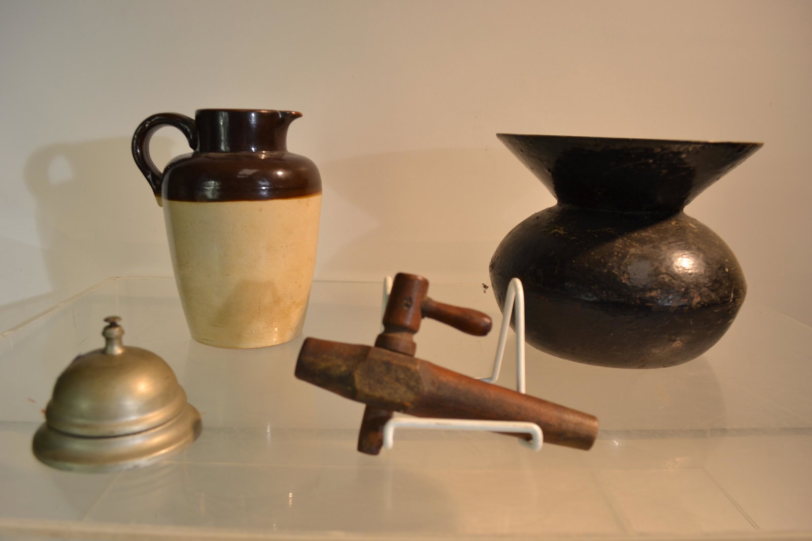 Mixed Country Grouping: Including a cast iron spittoon measuring approx. 6 1/2"h, weight approx 7 lbs, a vintage stone ware pitcher, a store bell (has a great sound), and a wooden tap.
