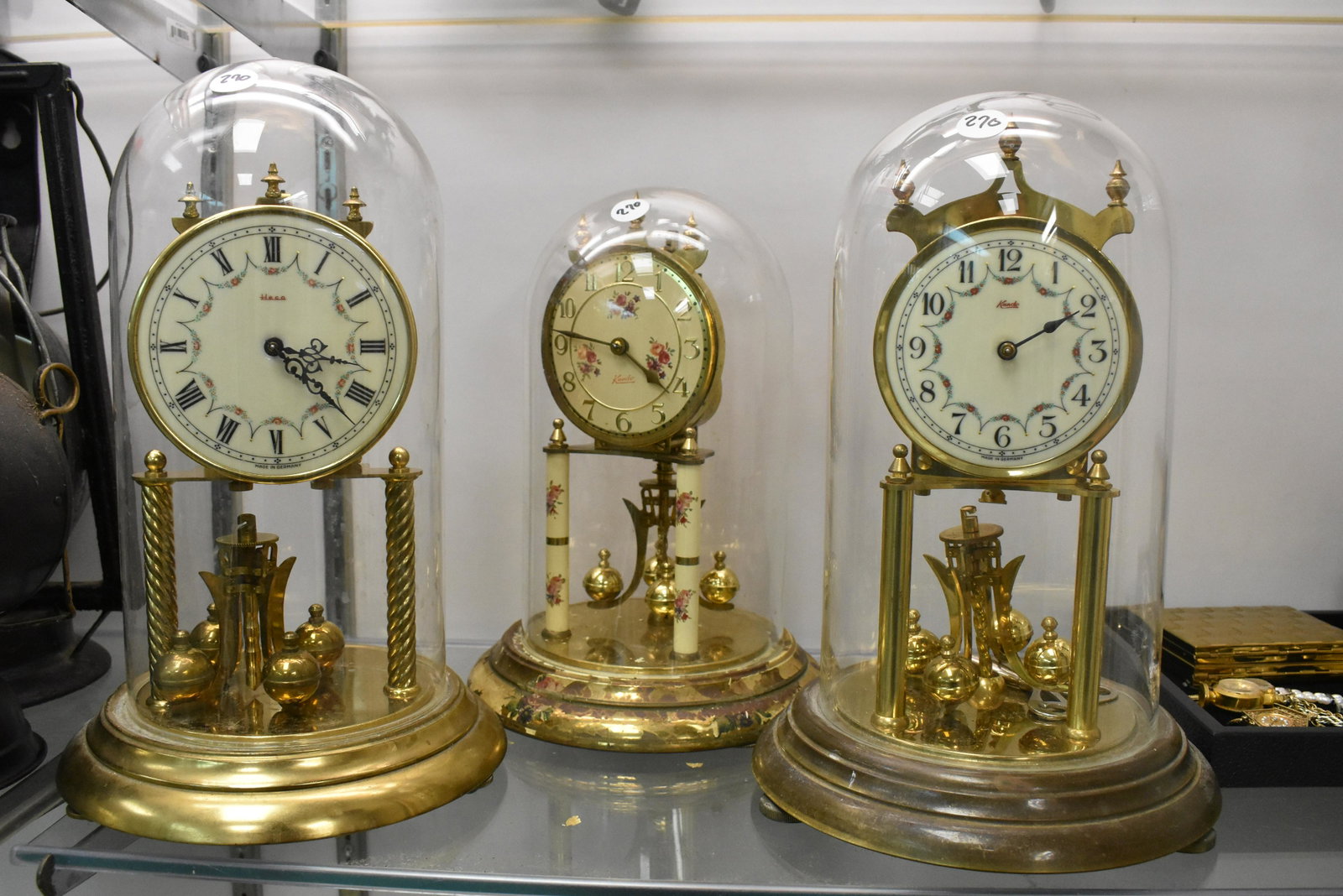 Three German Anniversary Clocks: Largest measures approx. 12 1/2"h and was made by Hecco. The others were made by Kundo and one shows paint loss, discoloration on base.