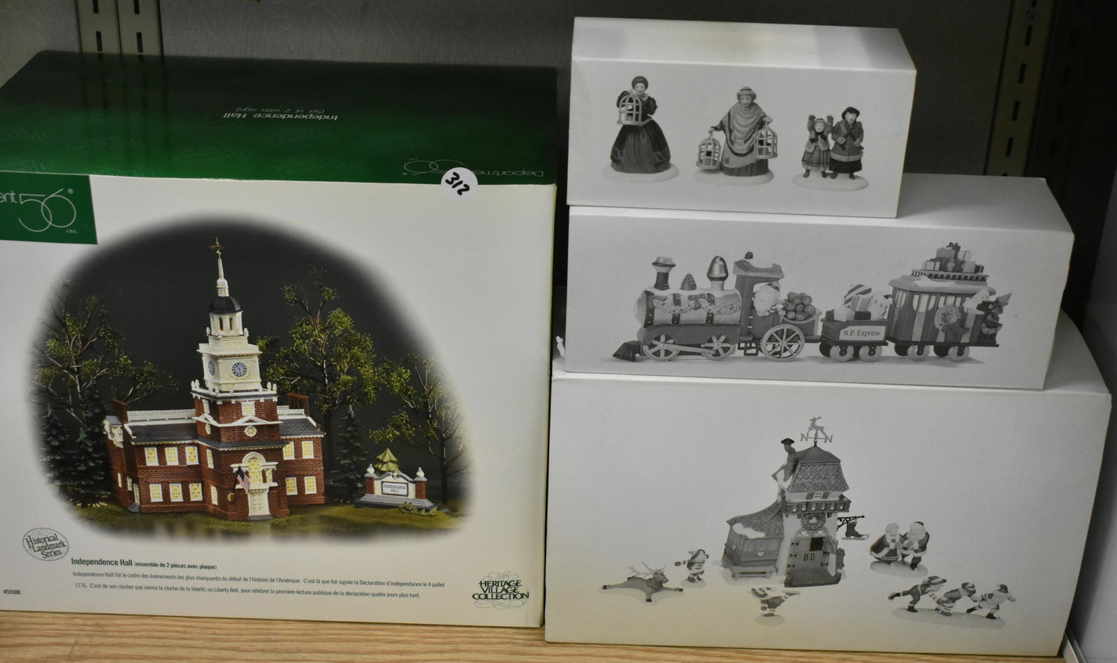 Dept 56 Mixed Grouping NIB (4): Independence Hall, Peppermint Skating Party, North Pole Express and The Bird Seller.