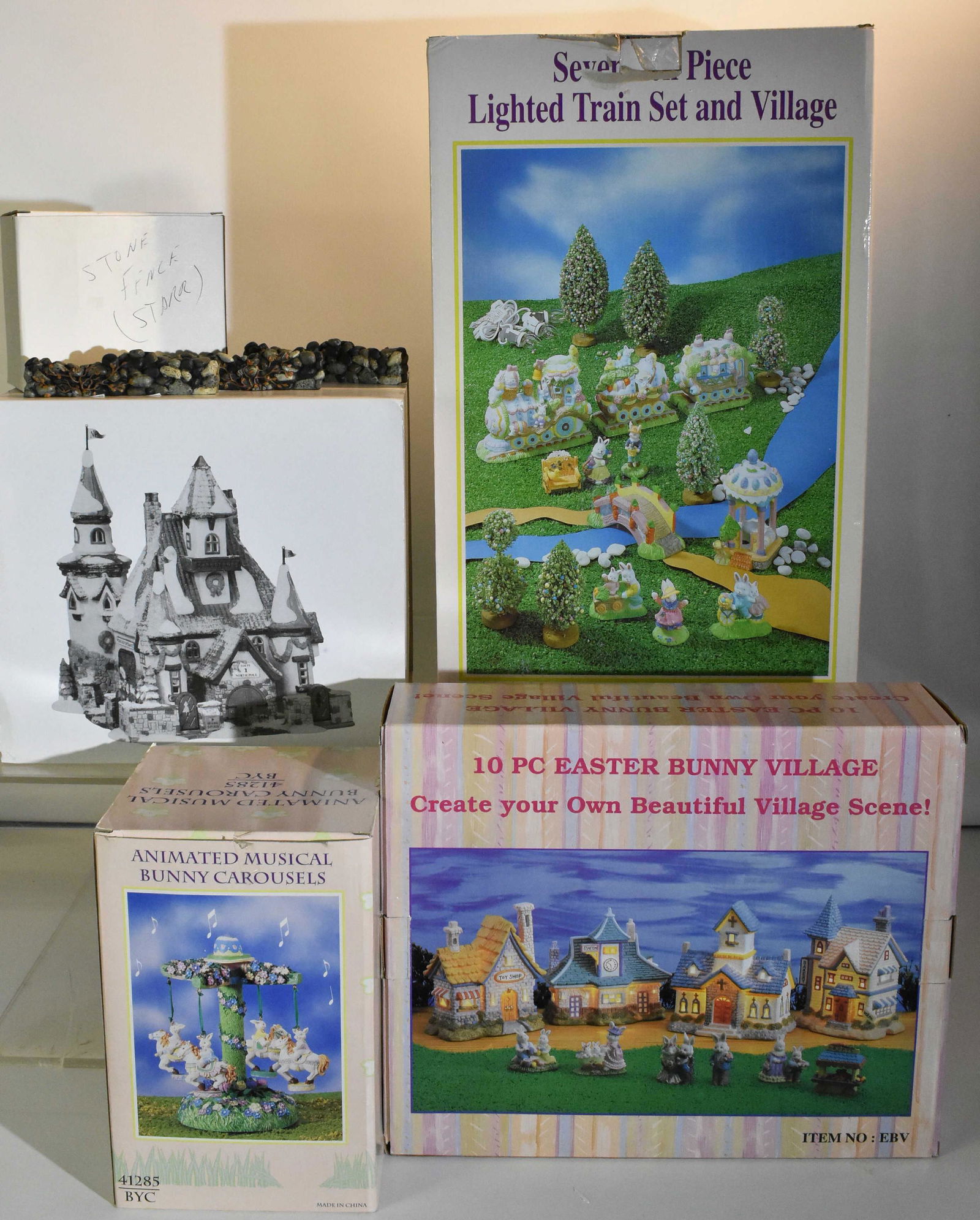 Dept 56 and more NIB: Dept 56 Home of Mr and Mrs Claus and unrelated items including a 10 piece Easter Bunny Village, a 17 piece lighted train set, an animated musical bunny carousel and a box of stone fencing. Five total