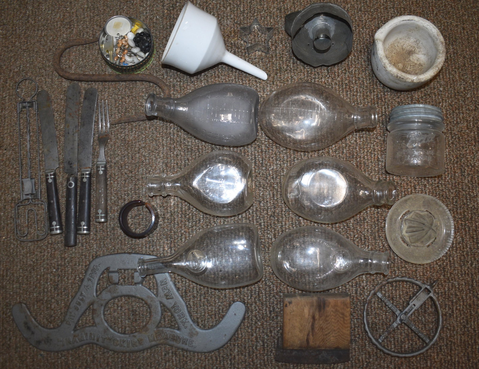 Country Kitchen and Nursing Bottles Grouping: Including four bone handled utensils, a 19th century can opener, an ironstone funnel with sieve, a half pint jar, an "inaminit" patent 1905 skirt measure and more. Six Ovoid Nursing Bottles Largest me