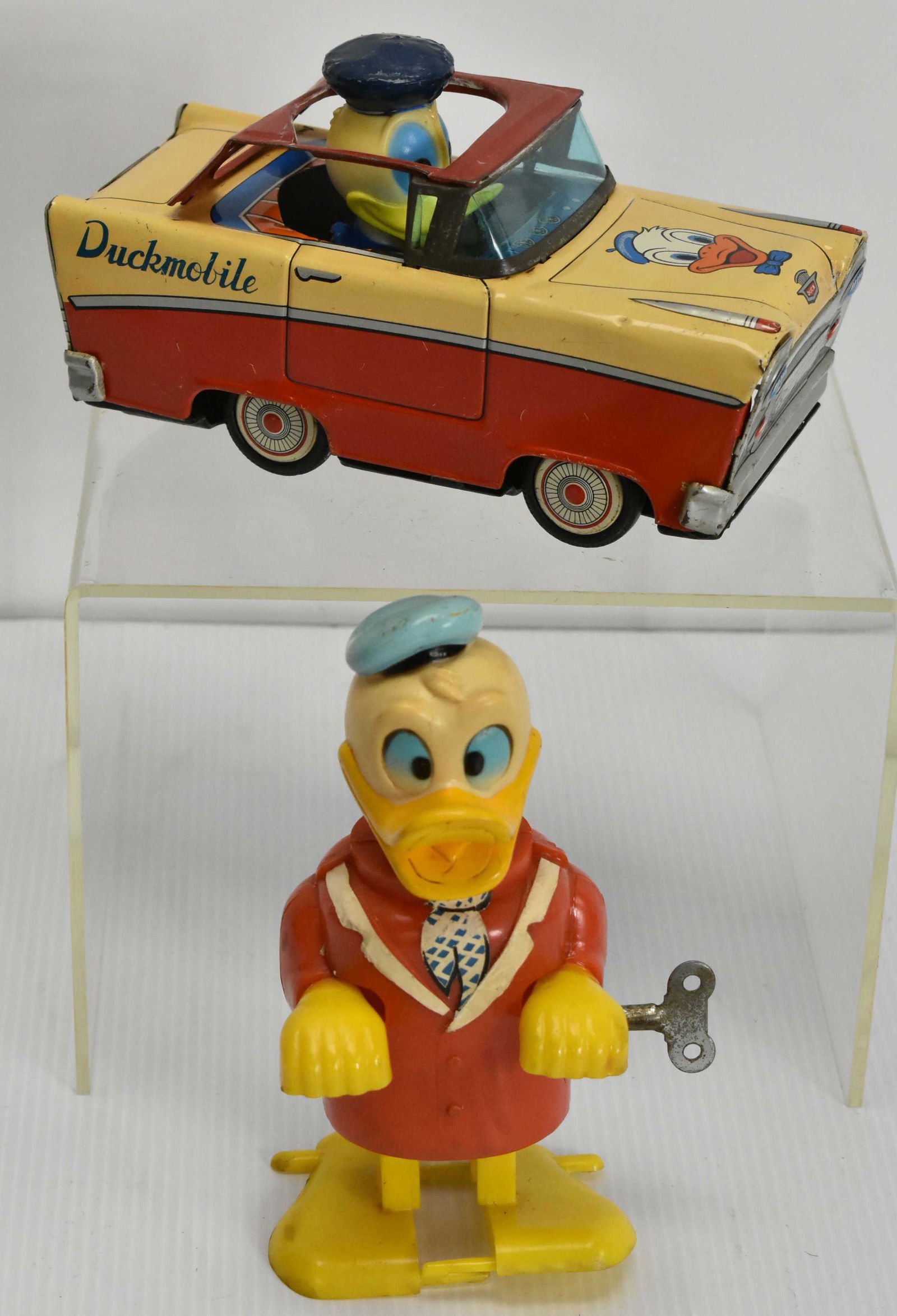 Vintage Wind Up Daffy Duck and Friction Duckmobile: Daffy Duck is marked Durham Industries Inc Made in Japan on back and under foot. Copyright 1972 Walt Disney Productions. Some paint and paper (tie and lapel) loss. Lot also includes friction powered D