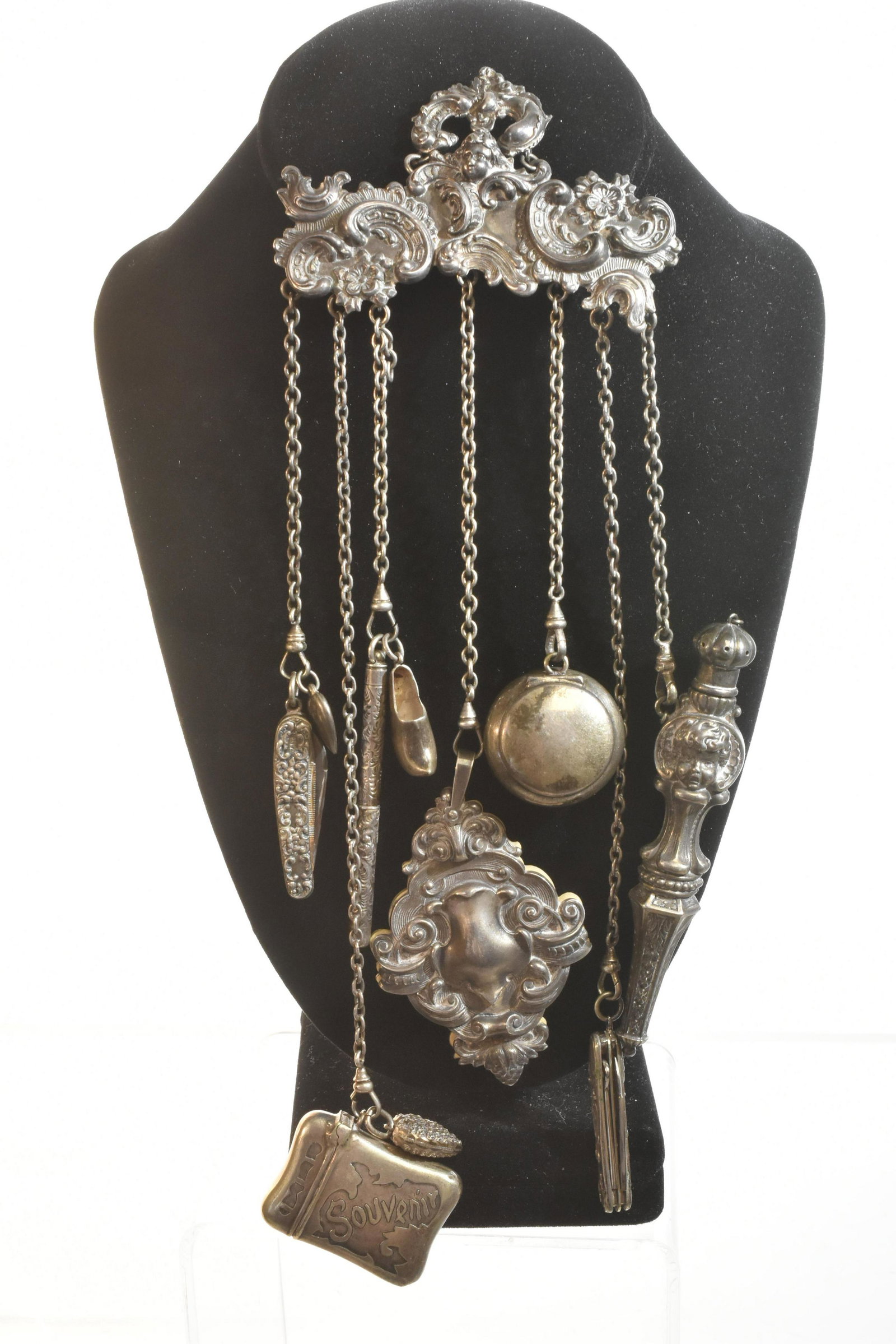 Extraordinary, Rare Sterling Kerr Chatelaine: Includes a putti holder with a large ornate putti scent bottle, two folding knives - one with a heart charm, a pencil with a shoe charm, an ornate tablet, a pill box and a souvenir box with a heart ch
