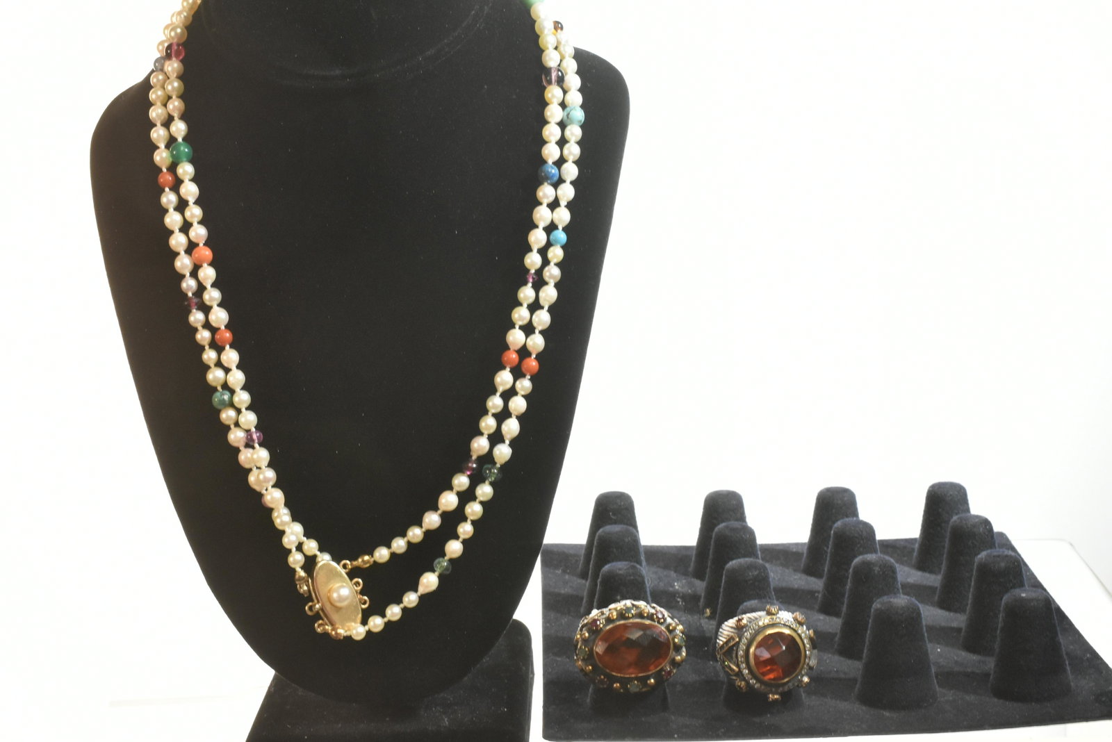 Designer Rings and a Pearl Necklace: There are two large ornate rings with fleur de lis designs and large citrine stones. Larger also has green and clear stones. Lot also includes a double strand pearl necklace with turquoise, carnelian 