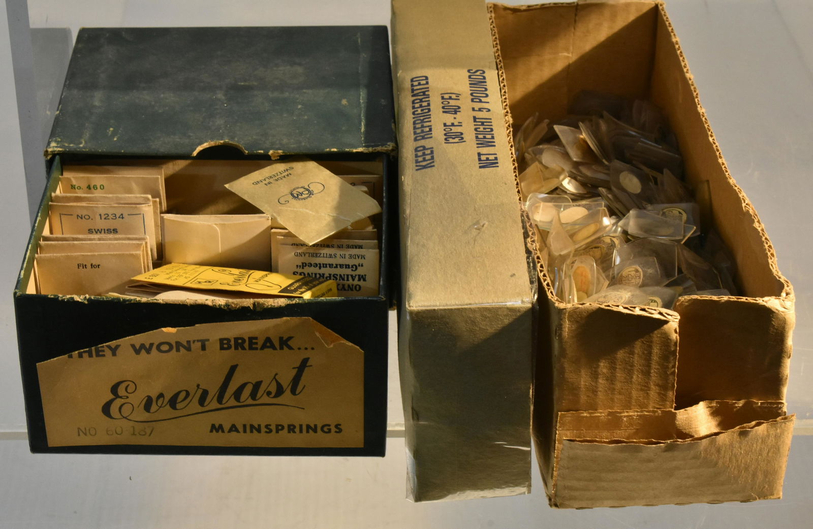 Grouping of Unused Watch Parts: Including Everlast main springs in original box and several hundred watch face glasses with original label.