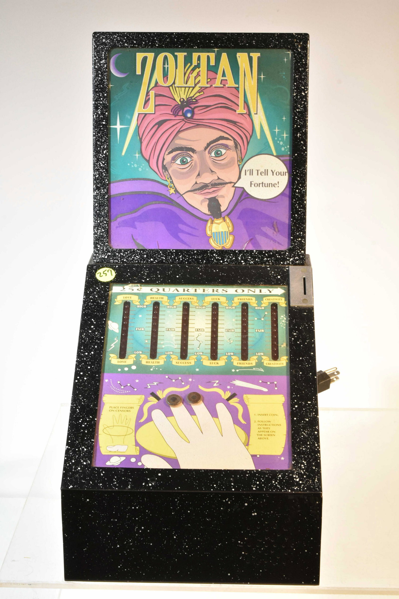 A Zoltan Electric Fortune Telling Game: It is a 25 cent game with good graphics. It has a metal body with glass over graphics. Comes with a lock and key and appears to be complete.