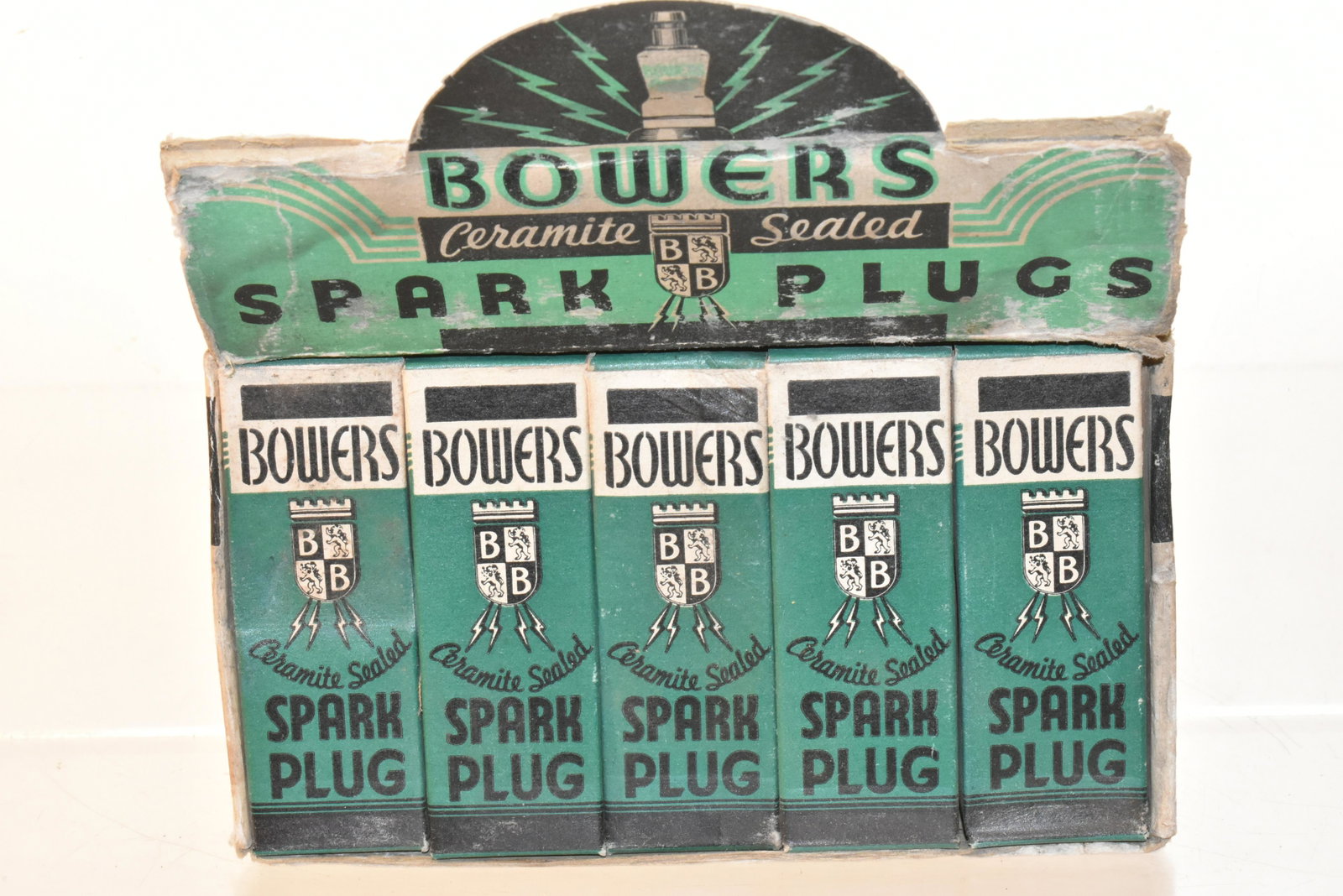 Bowers Spark Plug Store Display - Complete: Measures approx. 6"h x 6 1/2"w x 4"d. It is a cardboard display complete with all ten spark plugs in original boxes and was distributed by Bowers Battery and Spark Plug Company Reading, Pa.