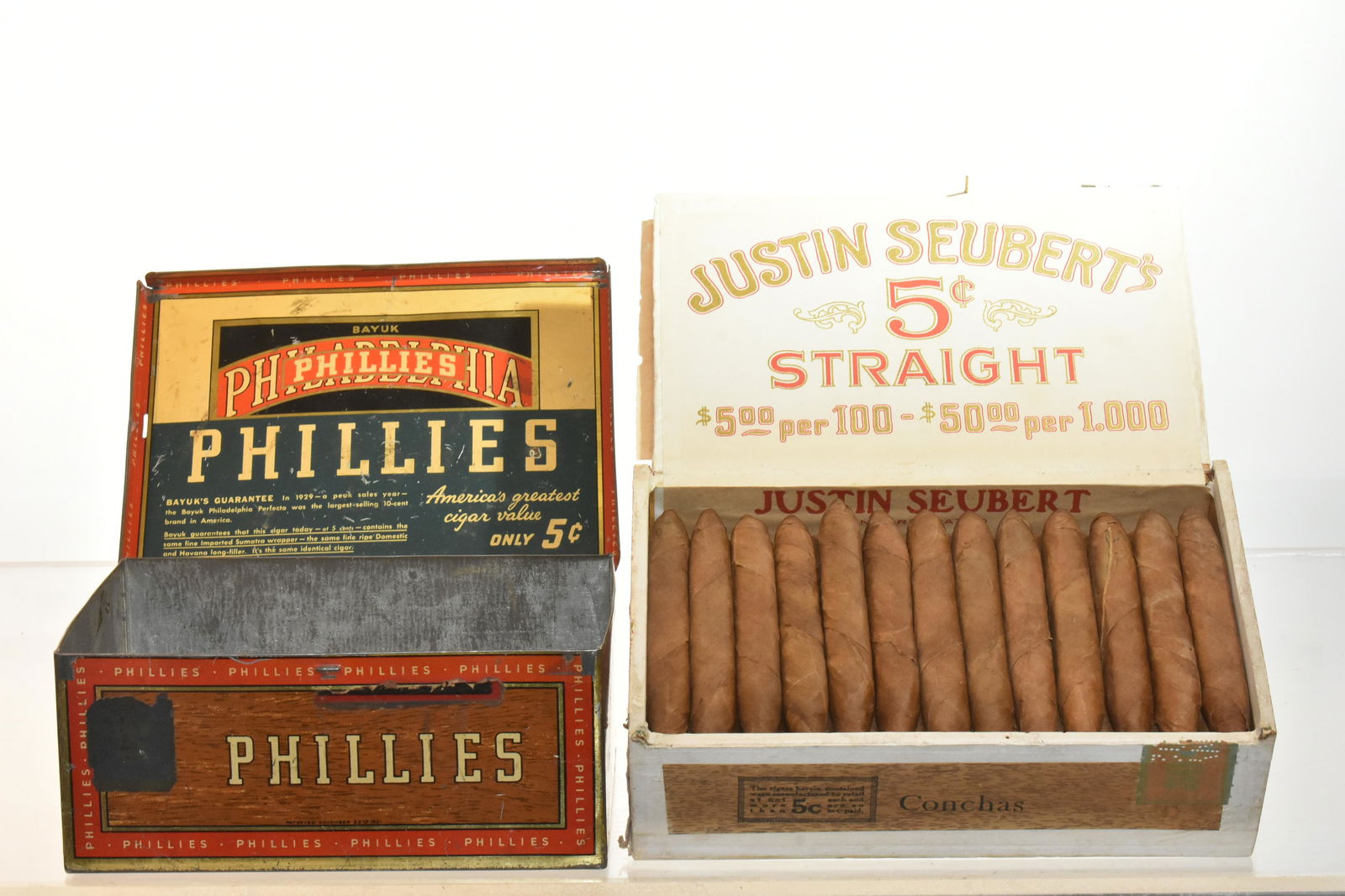 Vintage Tin Cigar Box and another: Tin cigar box measures approx. 3 1/2"h x 7 1/2"w x 5 1/2"d. It is Phillies 5 cent cigar box. It has 5 sided graphics on exterior and graphics inside lid. Lot also includes an unopened box of Justin Se