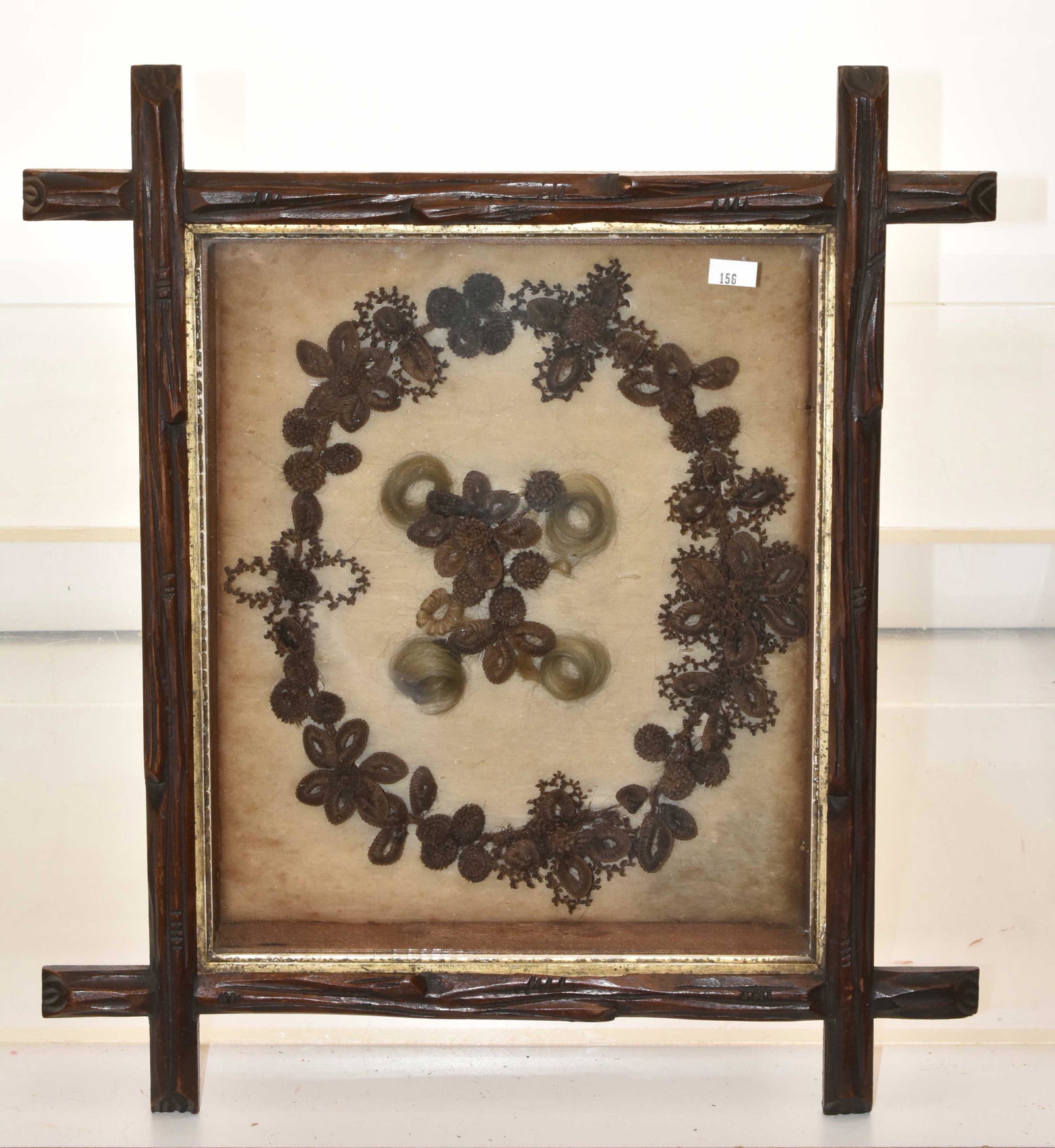 Victorian Hair Memoriam: Exposed area measures approx. 11 1/2"h x 9 1/2"w. Item is a shadow box with a cross work frame. It contains an intricately knotted wreath made of hair and other items. It is well executed and complete