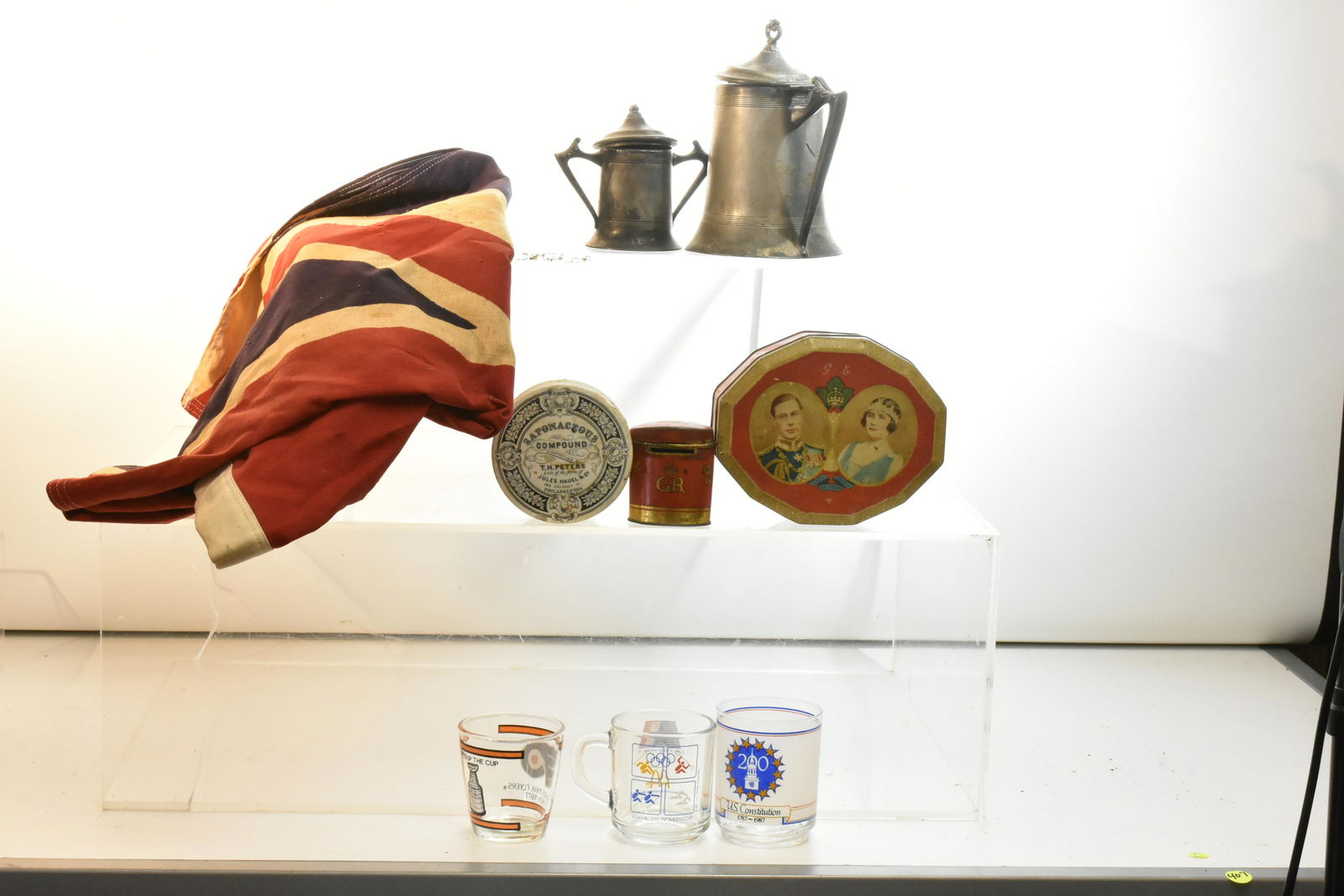 British Flag, Advertising and more: Including a 3 foot by 5 foot British flag made by Bulldog, a 1939 English Coronation tin, an Oxo-Cubes coronation bank, a 19th century Peter's Salve box as is, two pieces of vintage pewter and various