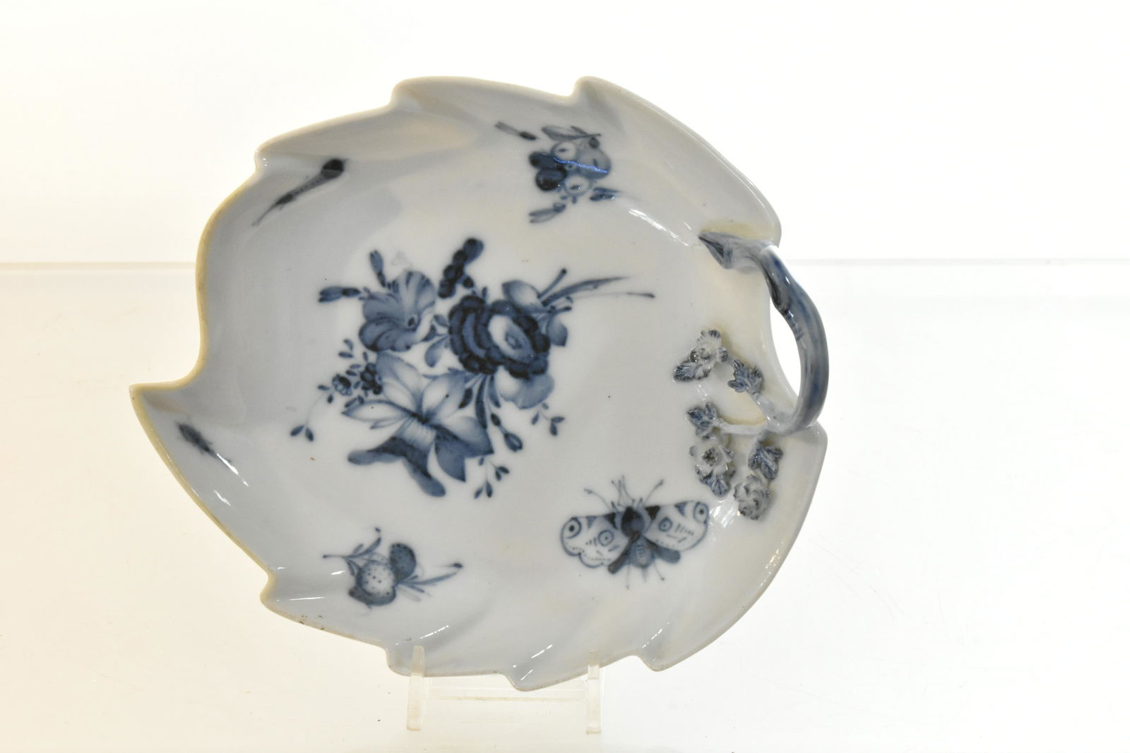 Meissen Leaf Condiment Dish: Measures approx. 7" in length. It has a butterfly and floral decoration with a raised vine and floral handle. Meissen crossed sword mark on back.