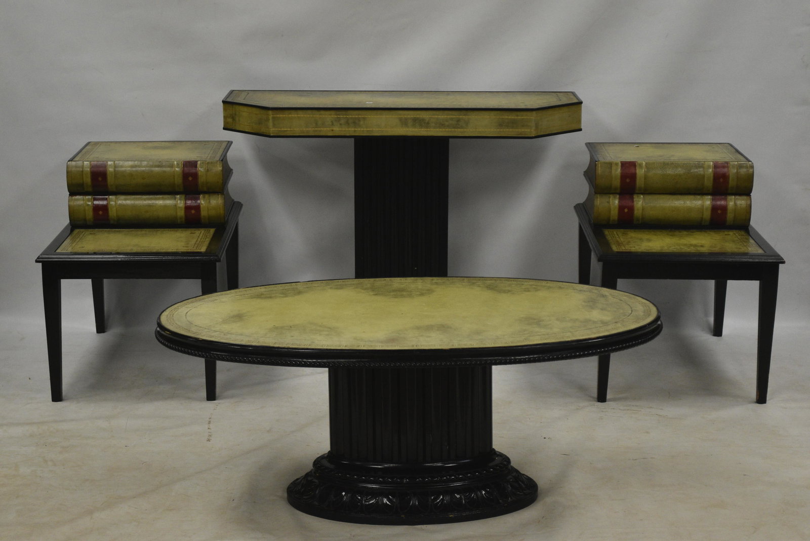 Four Piece Leather Top Table Set: Includes a wall table measuring approx. 31"h x 43"w x 16"d. Table has two cigarette burn marks, Also an oval coffee table and two end stands with book front doors.