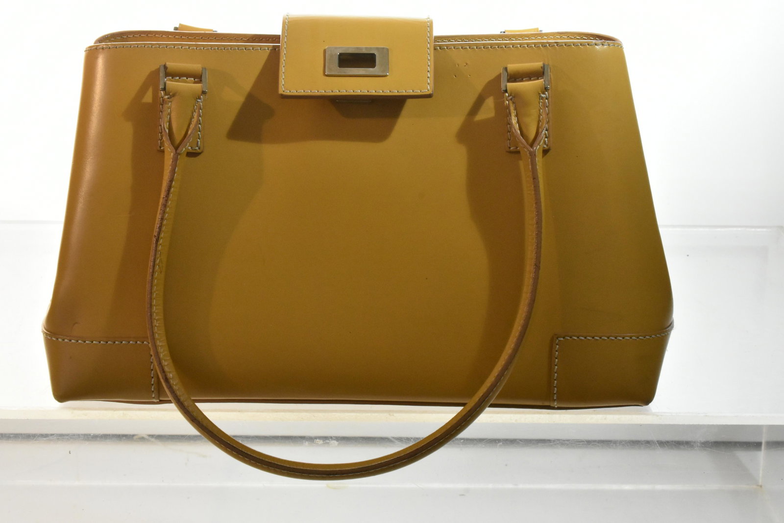 Lambertson Truex Handbag: A yellow camel leather two handled designer handbag with a logo brass closure, an interior brass tag and a sued interior.